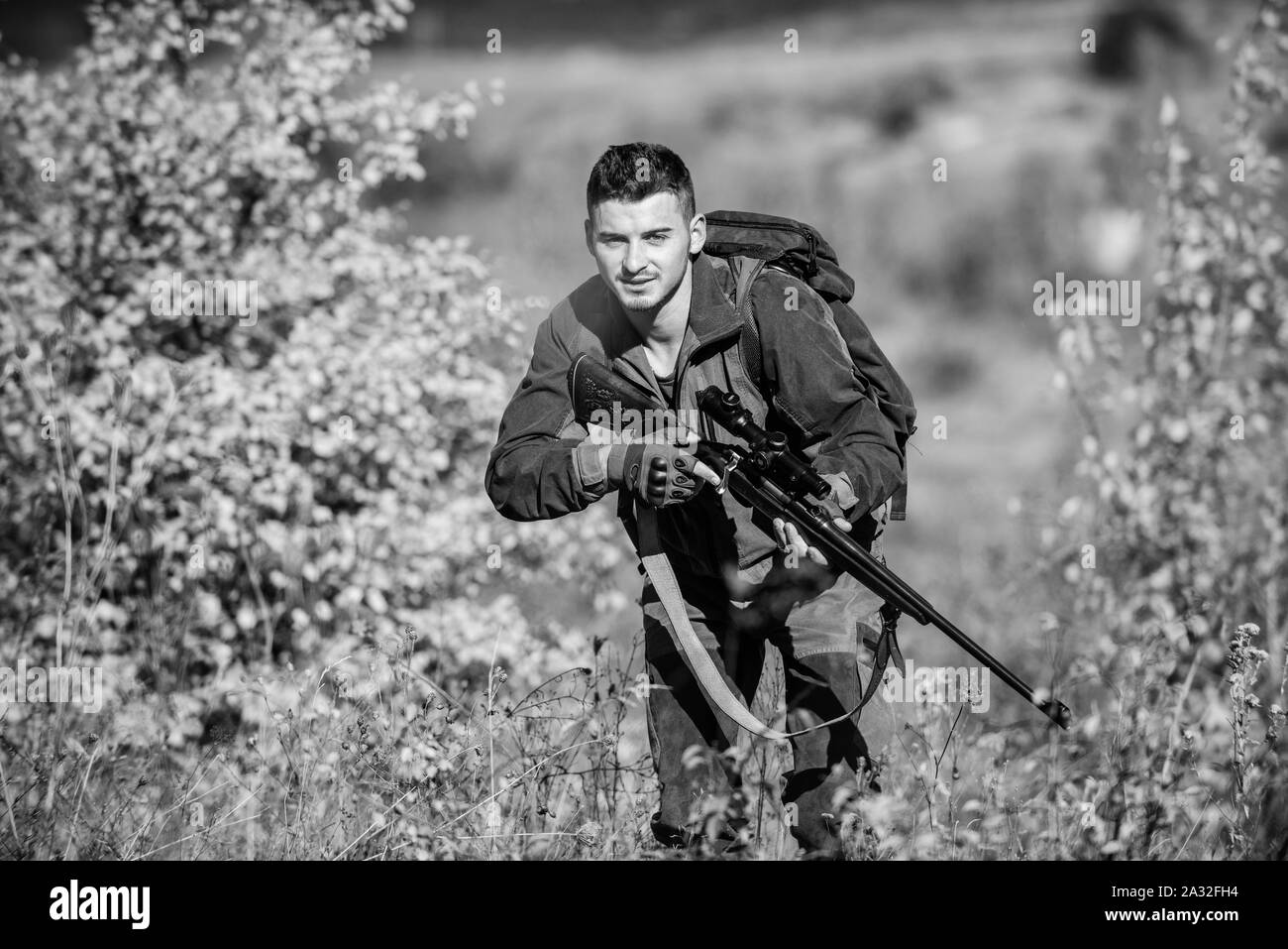 Bearded serious hunter spend leisure hunting. Hunter hold rifle. Man