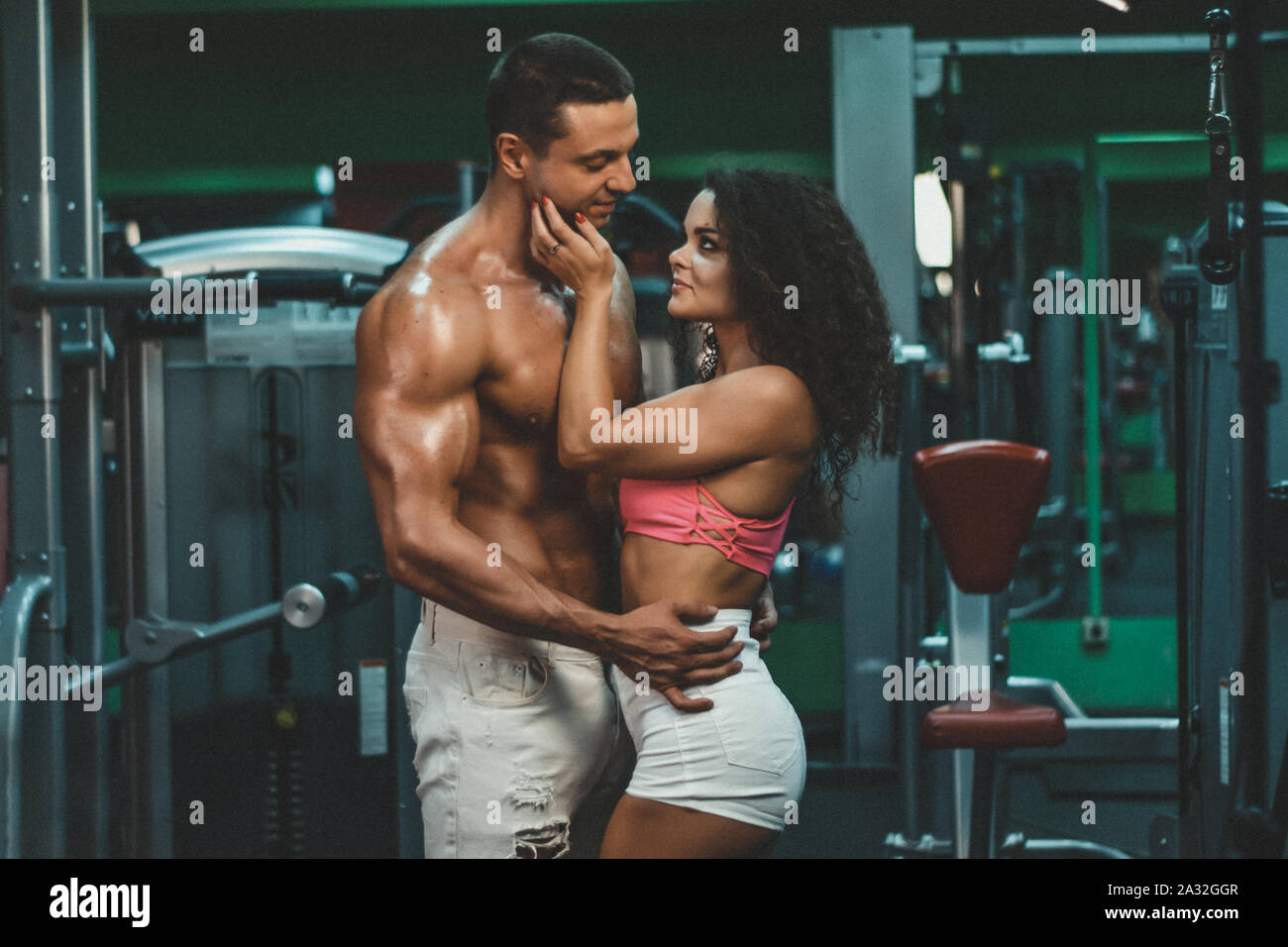 muscular woman and man in gym.sportive life. fitness. gym. hot curly woman. handsome bodybuilder. sportive couple in gym . Stock Photo