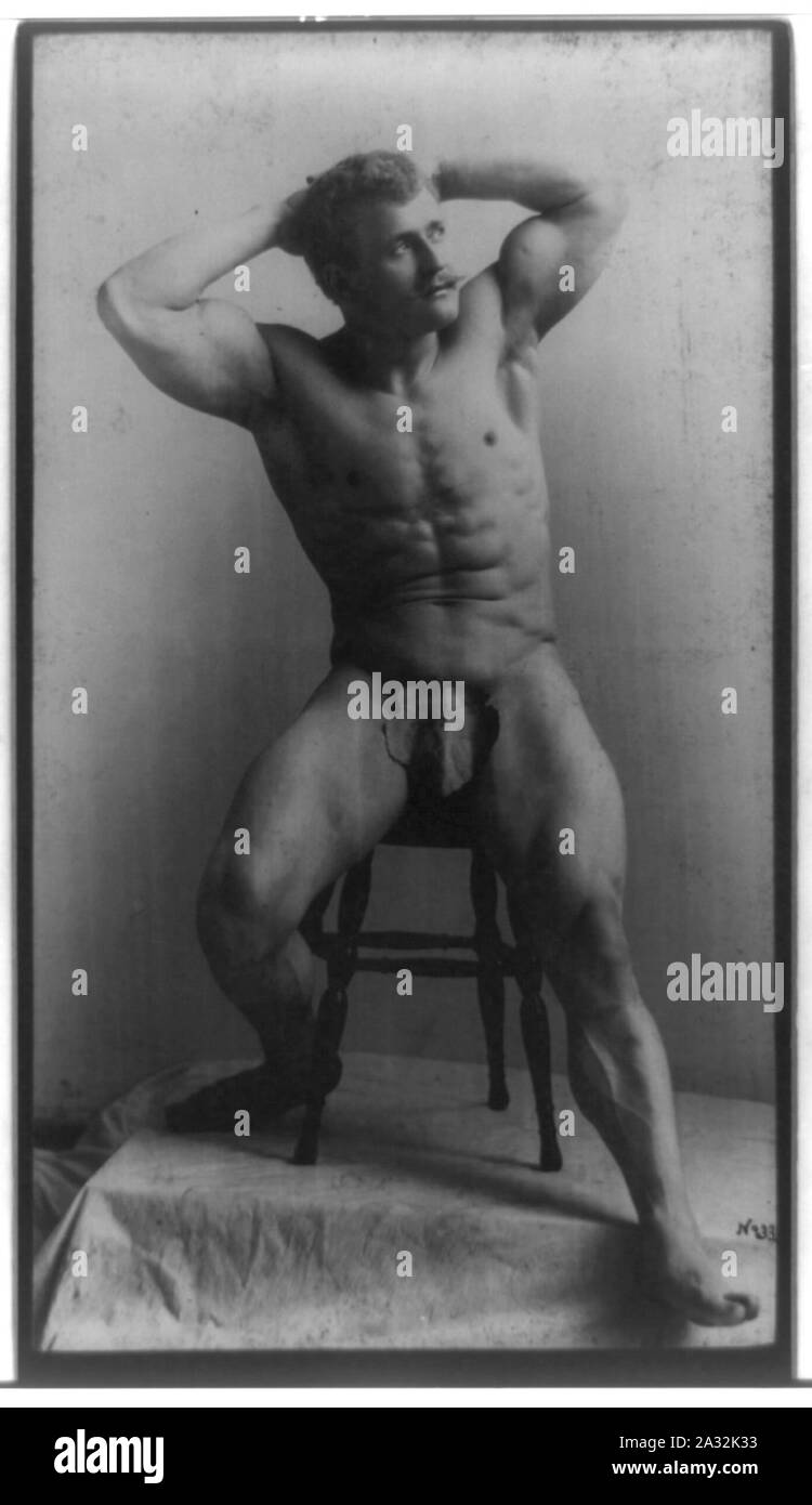 Eugen Sandow, full-length portrait, seated on stool facing right, hands behind head, wearing fig leaf Stock Photo