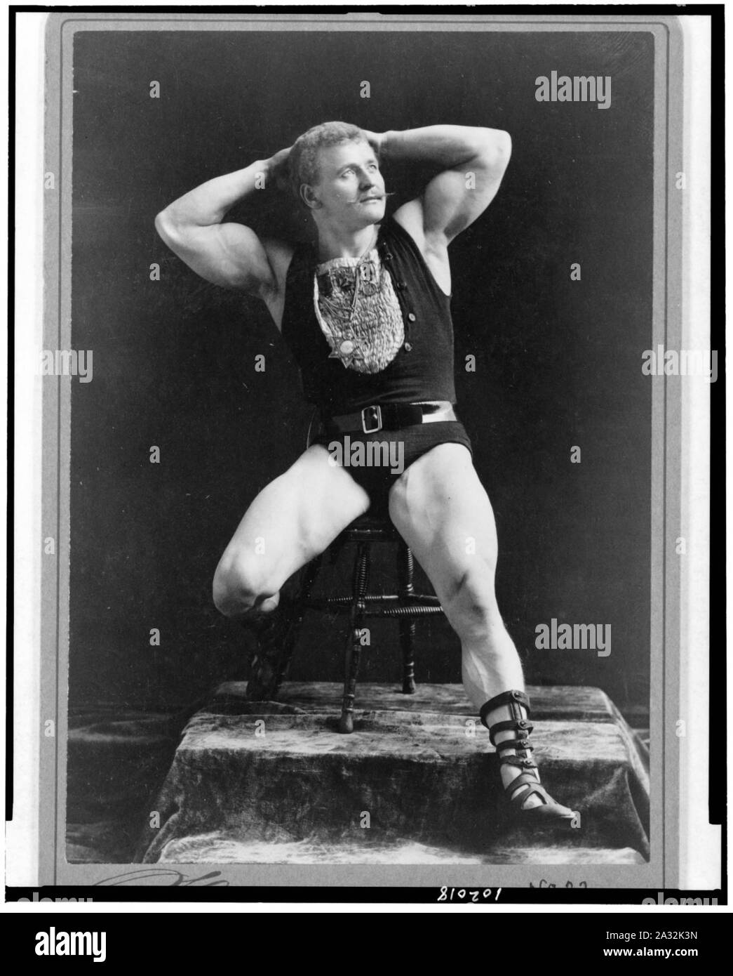 Eugen Sandow, full-length portrait, seated, facing right, hands behind head) - Sarony, 37 Union Sqr., N.Y Stock Photo