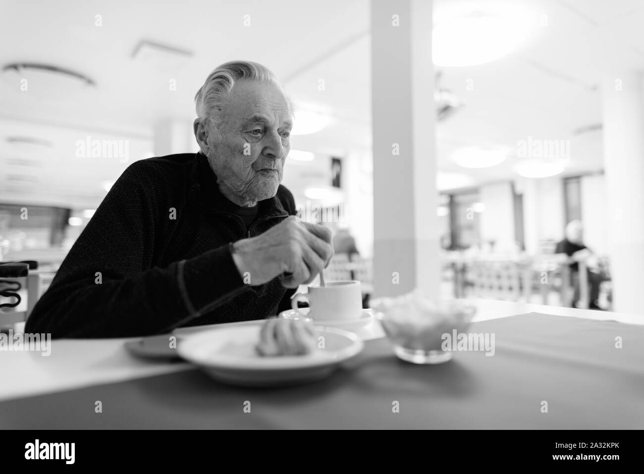 Senior man eating at the cafeteria in nursing home Stock Photo