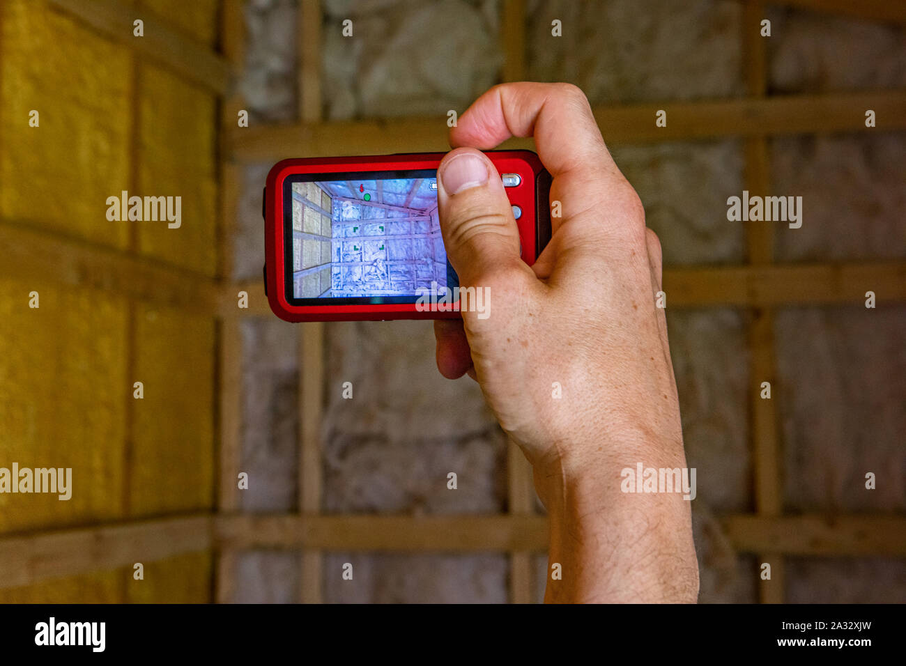 Home inspector photographing timber frame building cavity walls filled