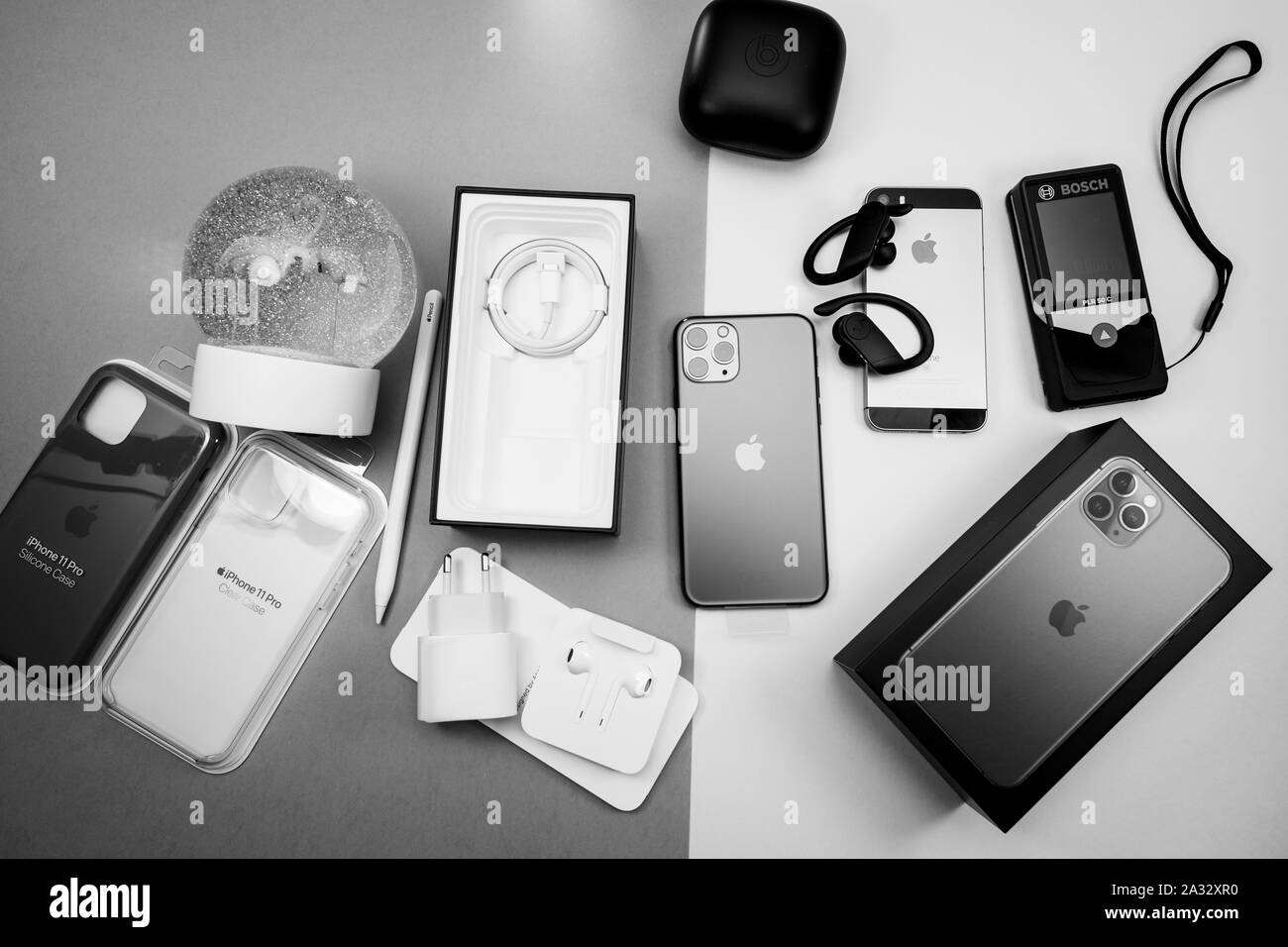 Paris, France - Sep 20, 2019: Unboxing of the lastest iPhone smartphone with triple-camera lenses latest iPhone 11 Pro by Apple Computers next to Beats by Dr Dre headphones black and white image Stock Photo