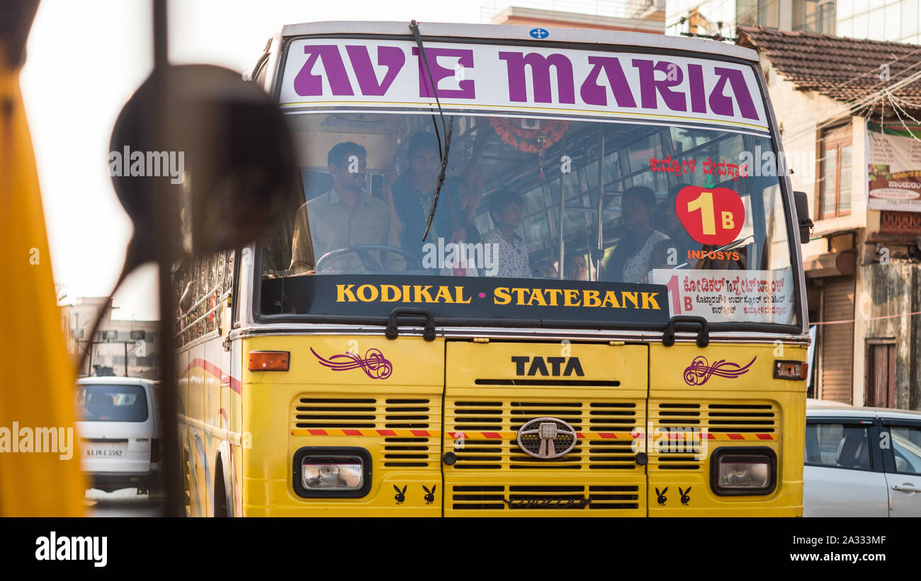 Public bus of Indian Tata Motors decorated with inscription 'Ave Maria' and Playboy logos, and passengers with the driver seen behind the windshield. Stock Photo