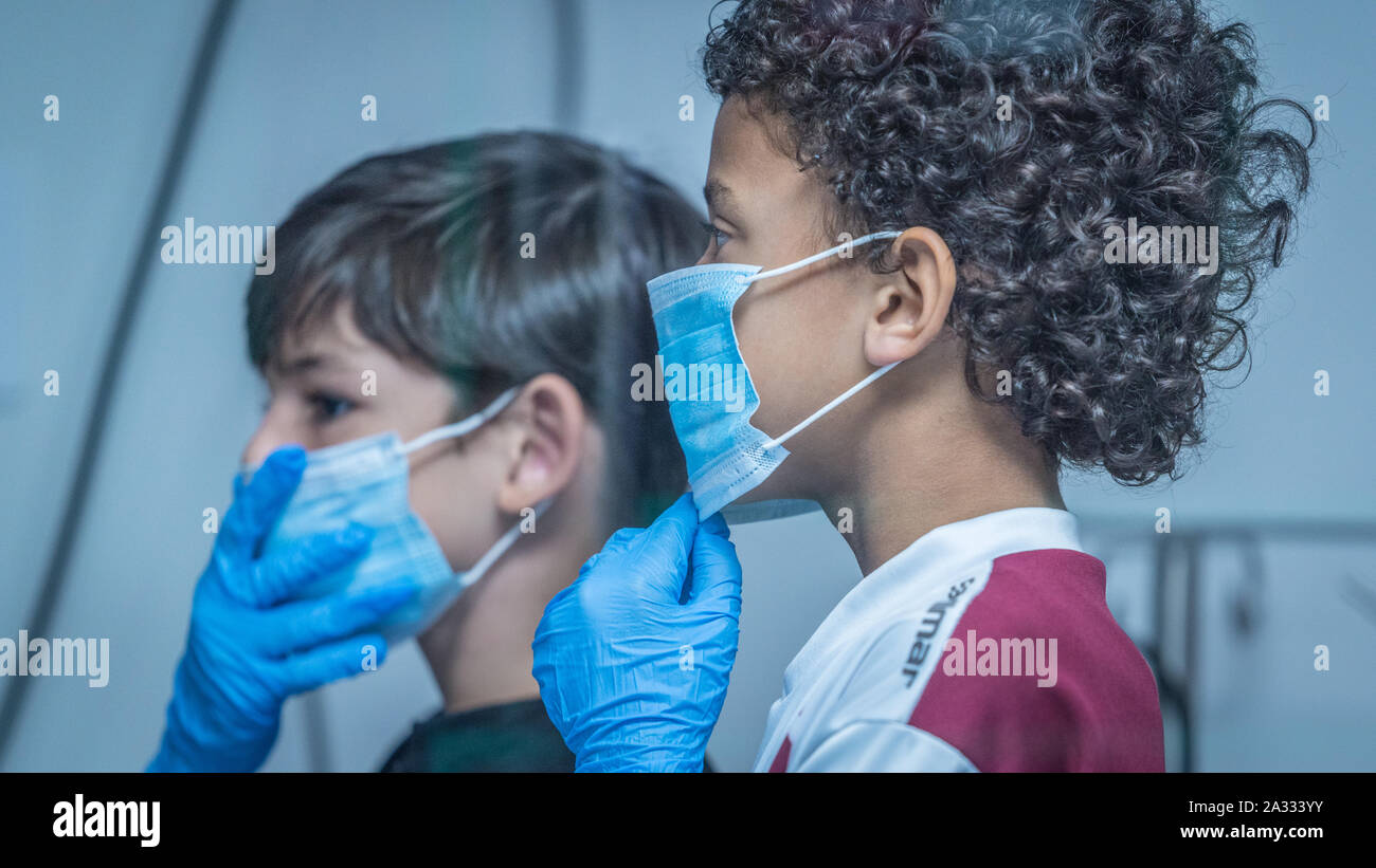 Two children wearing blue face masks and rubber gloves are impersonating doctors at Kidzania, Costa Rica Stock Photo