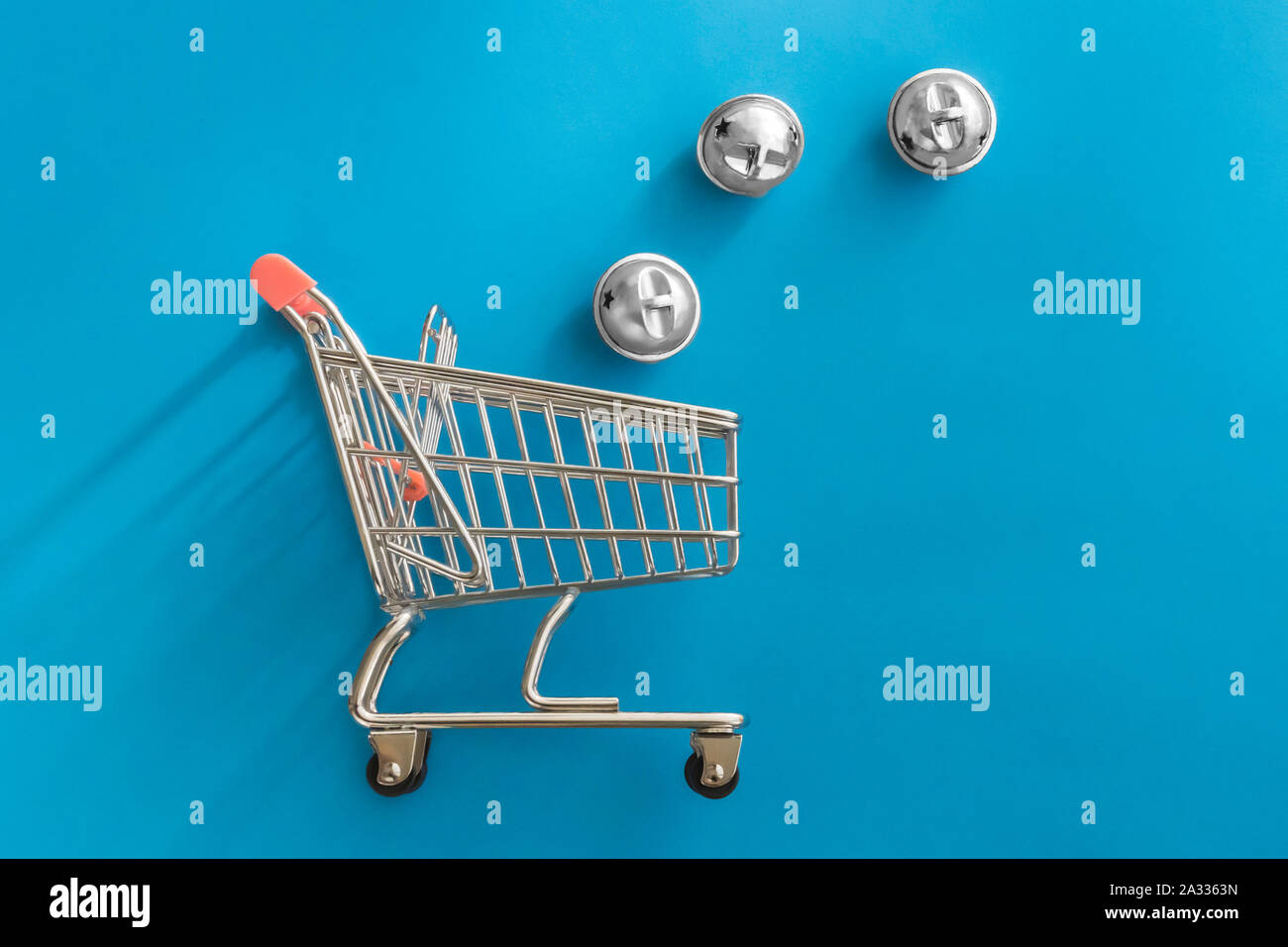 New Year or Christmass toys in trolley shopping cart on colorful blue background. Delivery service. Holiday, sale and discount concept. Stock Photo