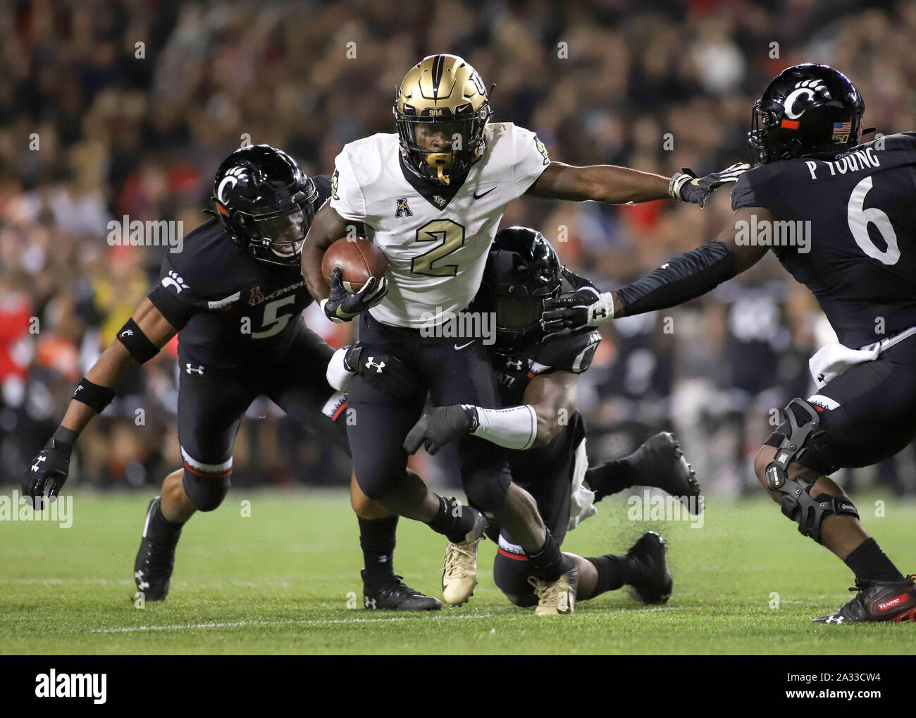 Cincinnati, Ohio, USA. 4th Oct, 2019. UCF's Otis Anderson (2) runs the ball and tries to evade Cincinnati's Darrick Forrest (5) and Perry Young (6) during an NCAA football game between the Cincinnati Bearcats and the UCF Knights at Nippert Stadium in Cincinnati, Ohio. Kevin Schultz/CSM/Alamy Live News Stock Photo