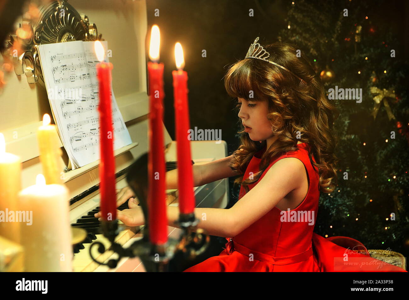 Beautiful girl in a red dress plays the piano Stock Photo - Alamy