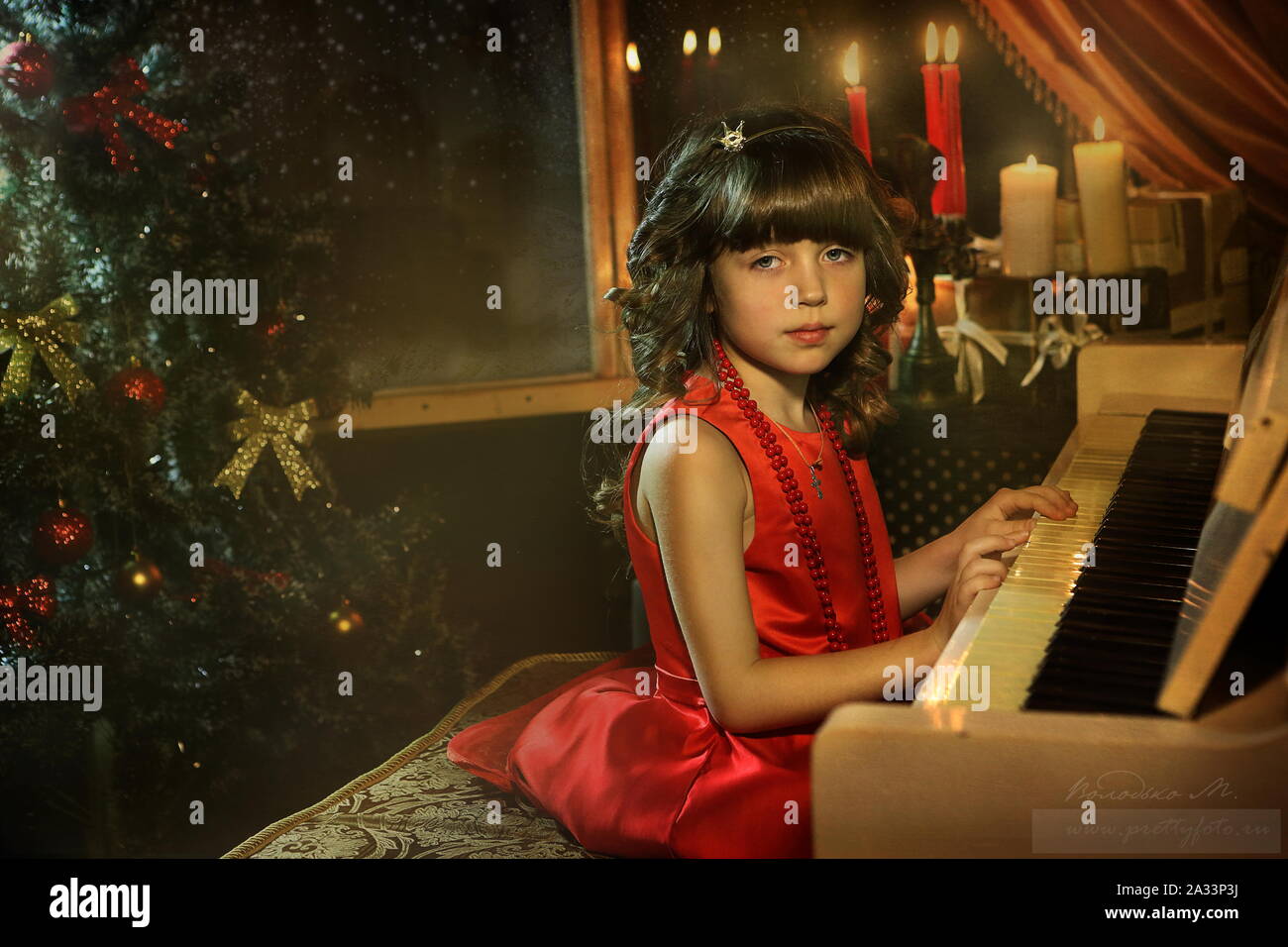 Beautiful girl in a red dress plays the piano Stock Photo - Alamy