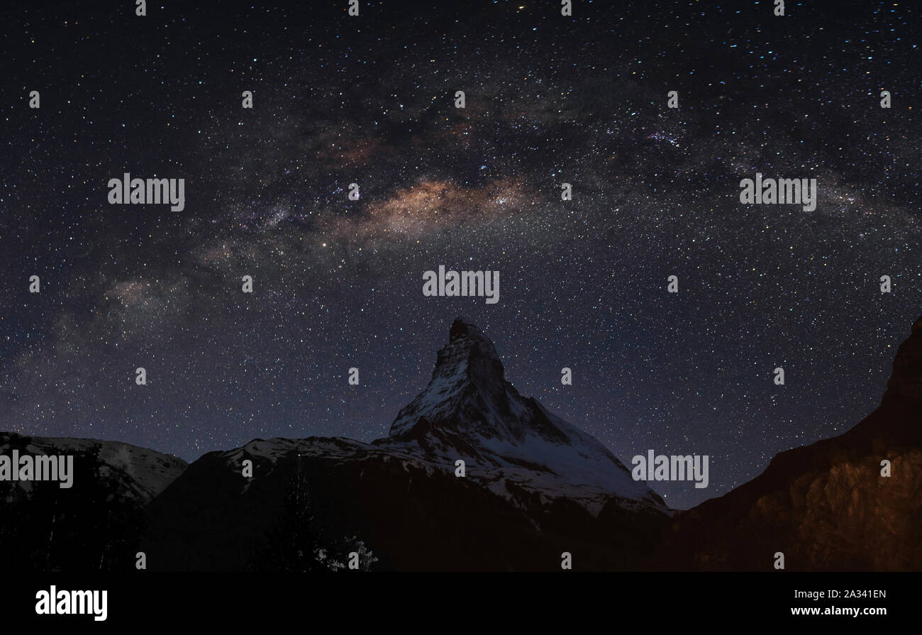 Panoramic Matterhorn mountain at night in Switzerland with starry sky and milky way Stock Photo