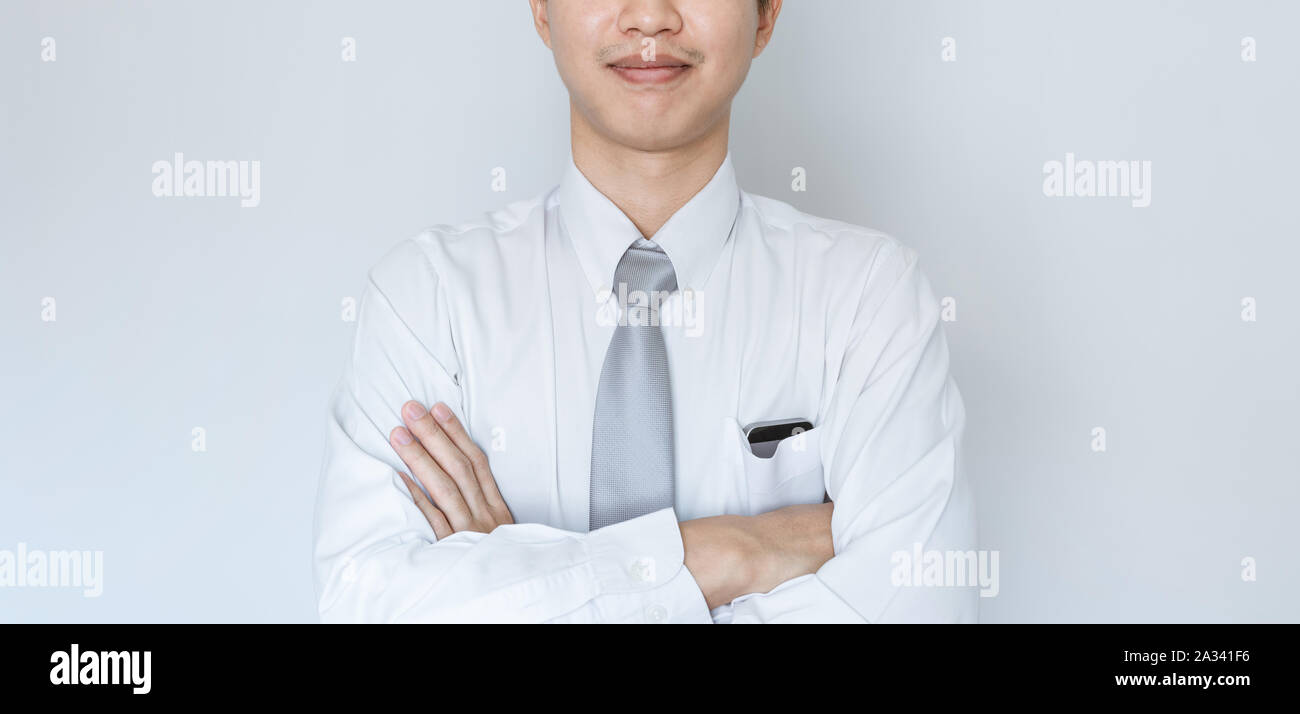 Business employee smiling in white shirt with arm crossed Stock Photo