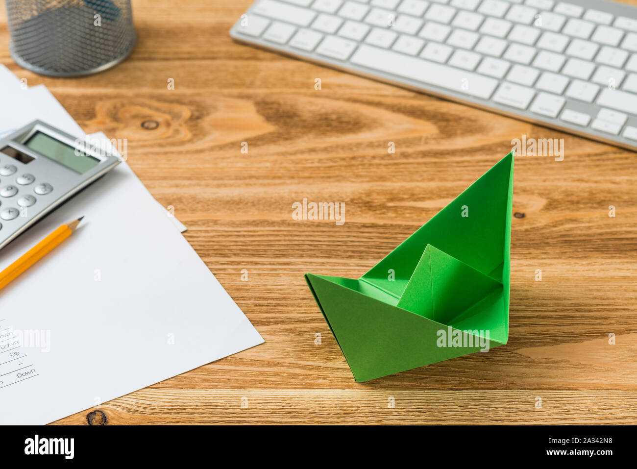 Top View Modern Office Workspace With Green Paper Ship Flat Lay