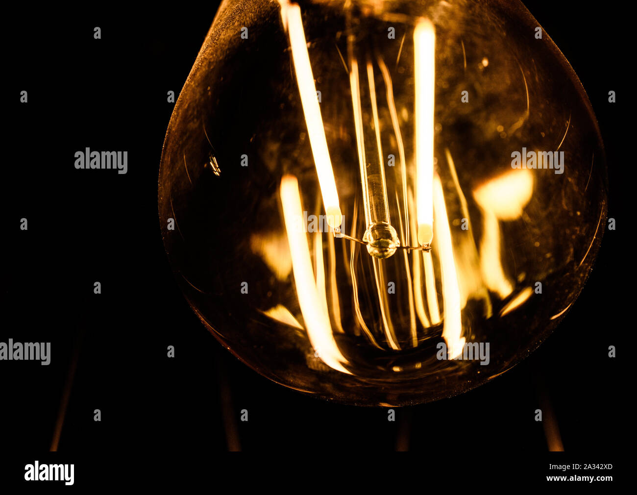 Closeup of Clear Retro Tungsten Light Bulb Isolated on Black Background Stock Photo
