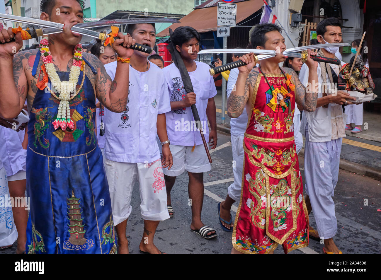 A procession during the Vegetarian Festival (Nine Emperor Gods Festival) in Phuket Town, Thailand, participants displaying cheeks pierced by swords Stock Photo