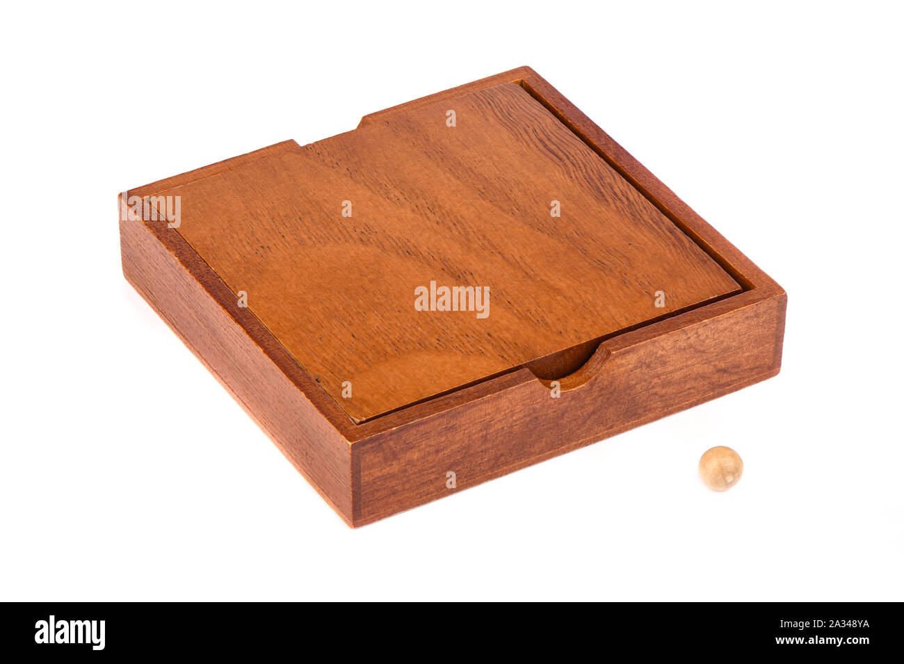 Wooden box and ball for playing Madagascar checkers over a white background. Madagascar checkers is a board game for one player. Board games concept. Stock Photo