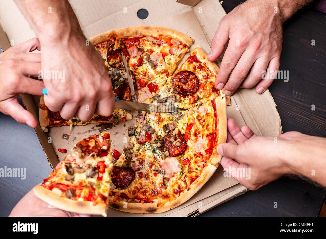 Пицца в мужских руках. Пицца круглая коробка квадратная а люди. Резать пиццу. Человек откусывает круглую пиццу. Почему пицца круглая а коробка