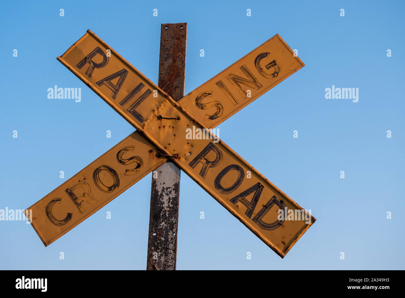Old and Worn Yellow Railroad Crossing Sign in Victoria Falls, Zimbabwe Stock Photo