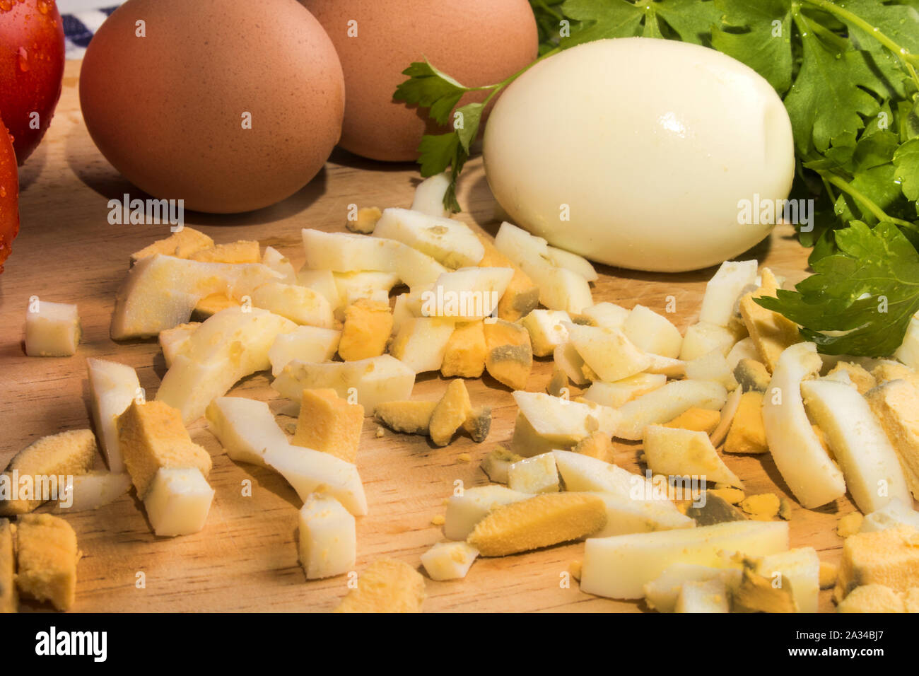 hard boiled eggs, also sliced for egg salad on a wooden board Stock Photo