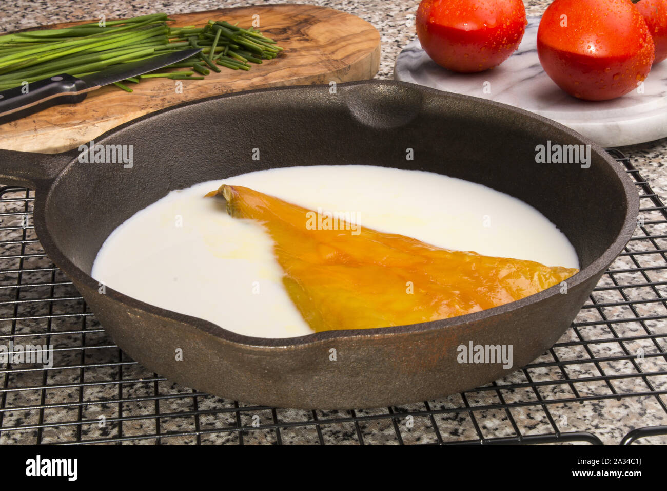smoked haddock fillet prepared in a cast iron pan with fresh milk Stock Photo