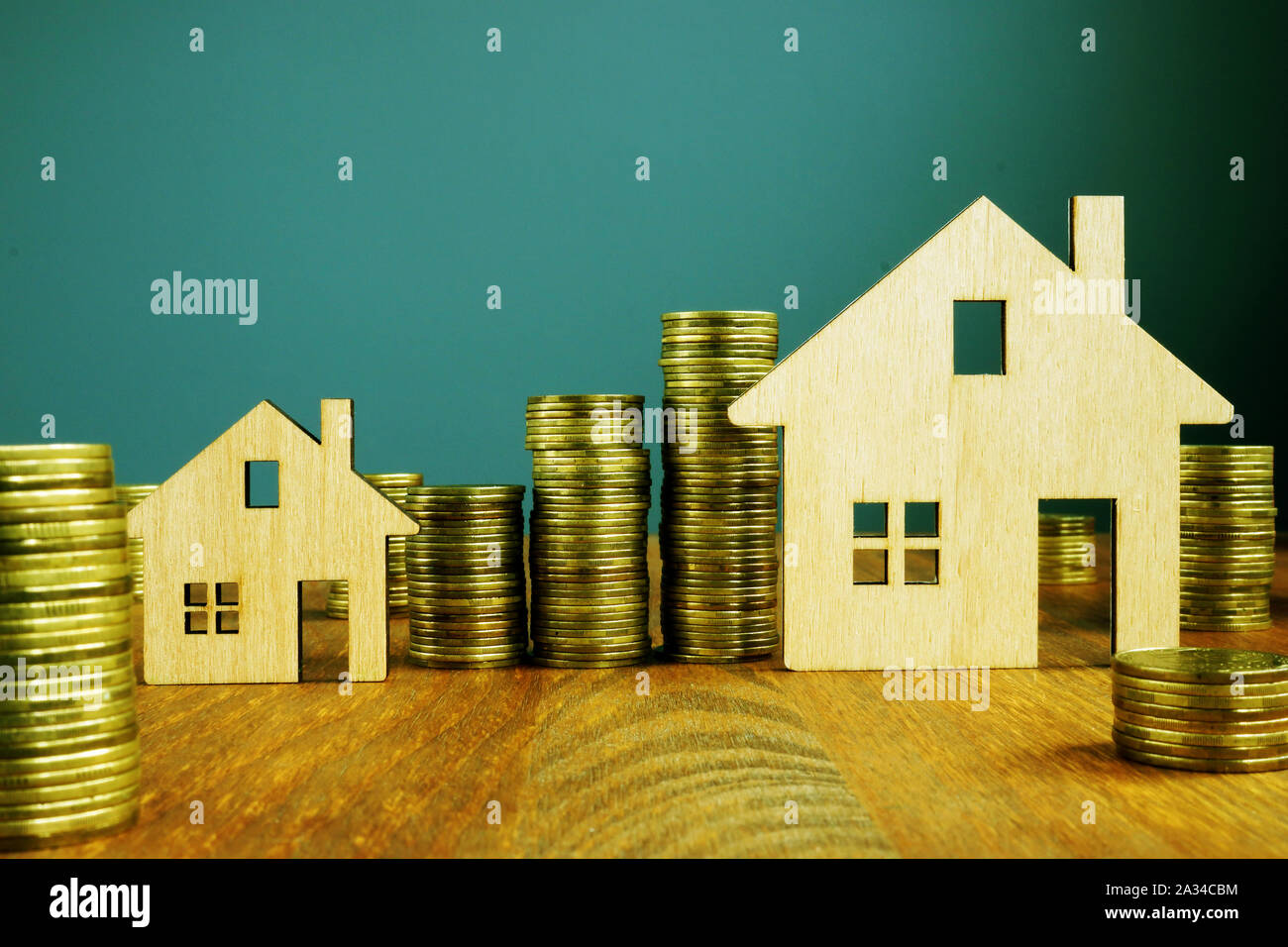 Investment Property concept. Wooden homes and increasing columns of money. Stock Photo
