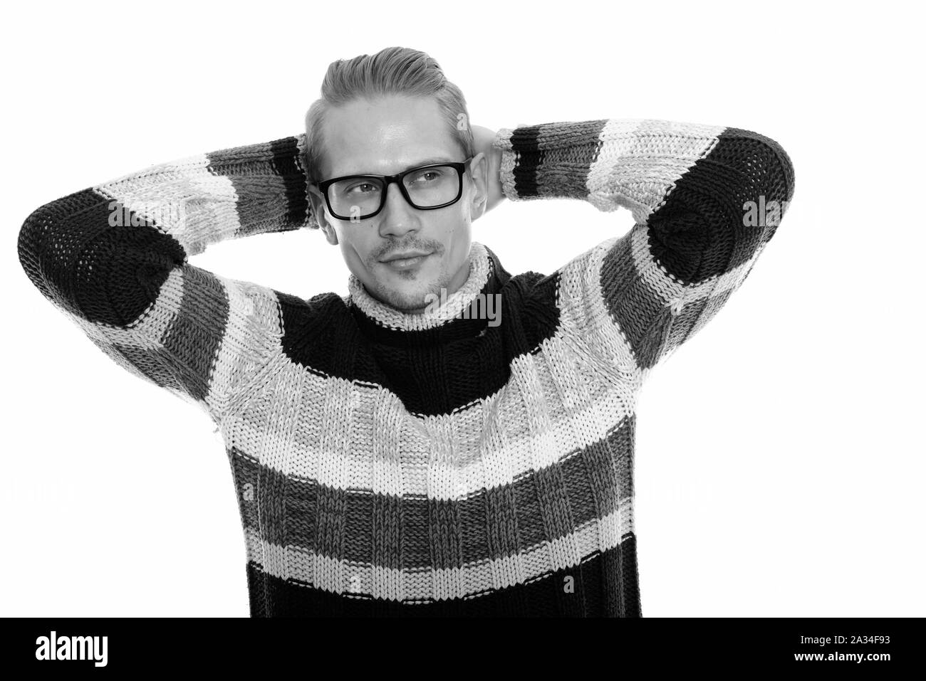 Studio shot of young handsome man thinking while wearing eyeglasses ...