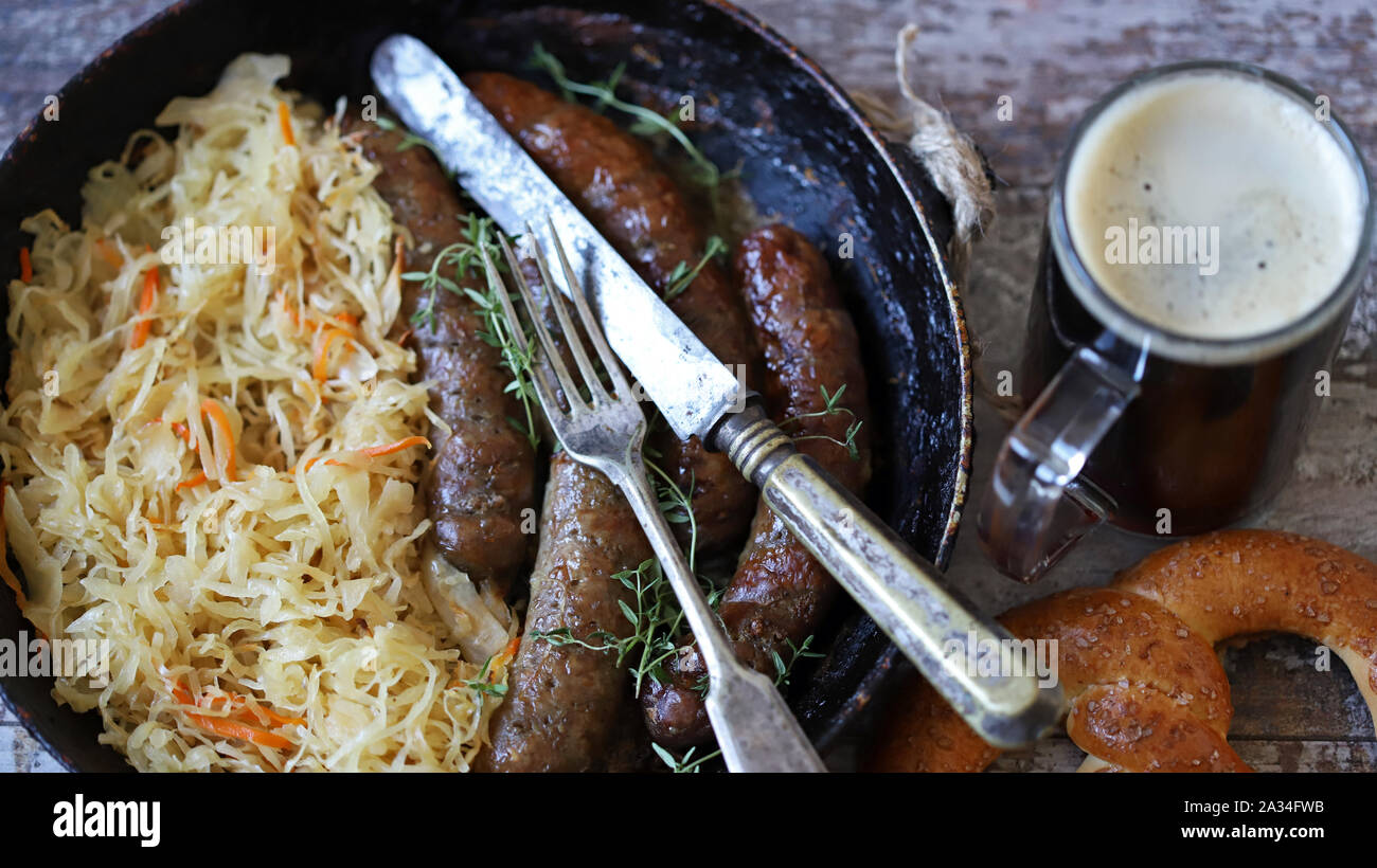 Oktoberfest food. Hot Bavarian sausages with sauerkraut in a pan. Delicious beer festival food