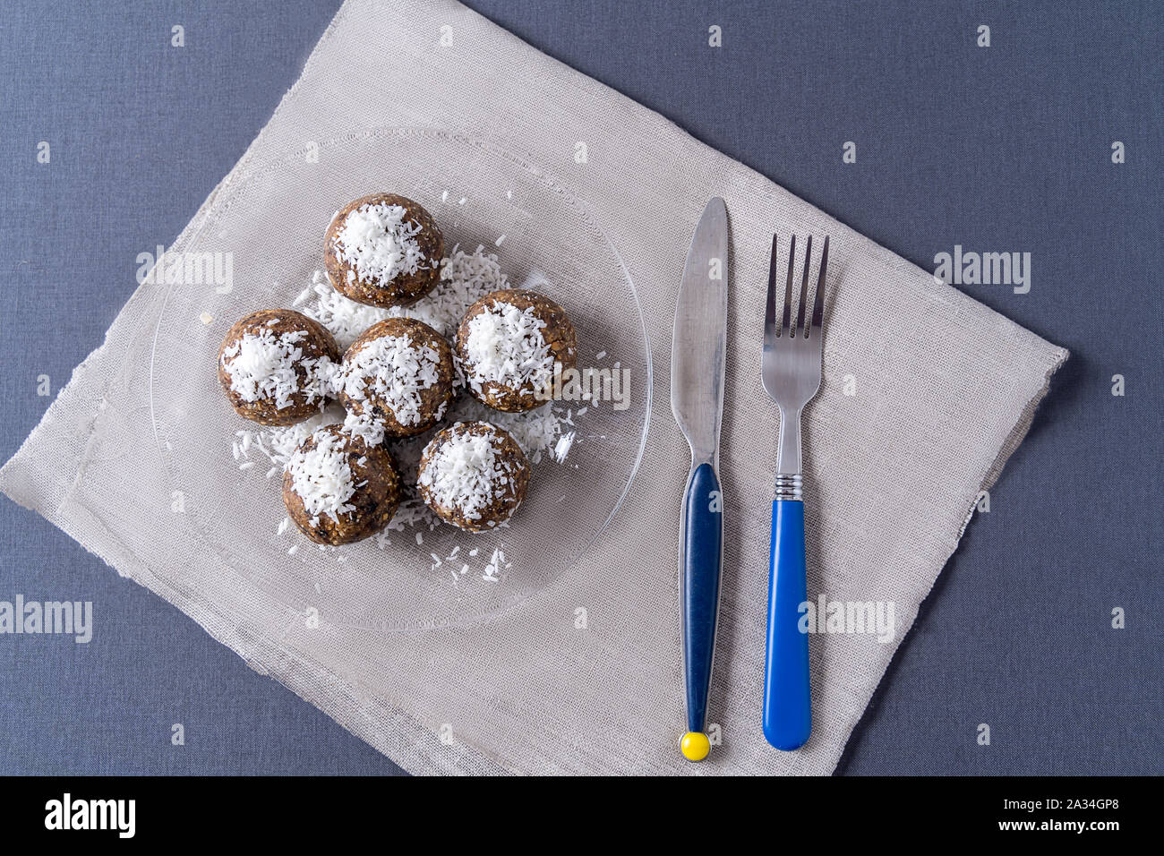 Healthy organic energy balls made with dates, prunes, raisins, peanut, in a plate on gray