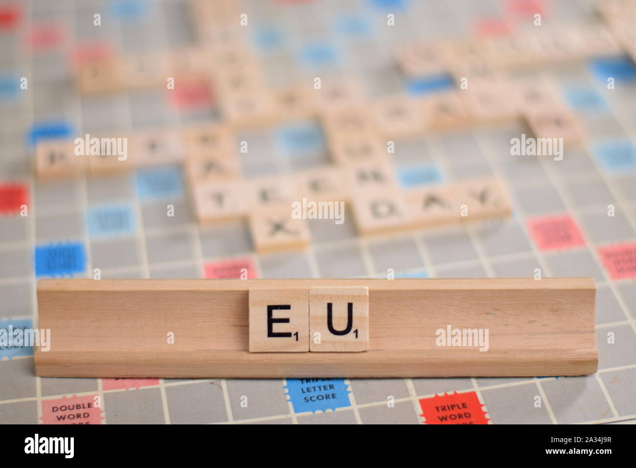 The name 'EU' (European Union) in wooden scrabble tiles on a rack ...