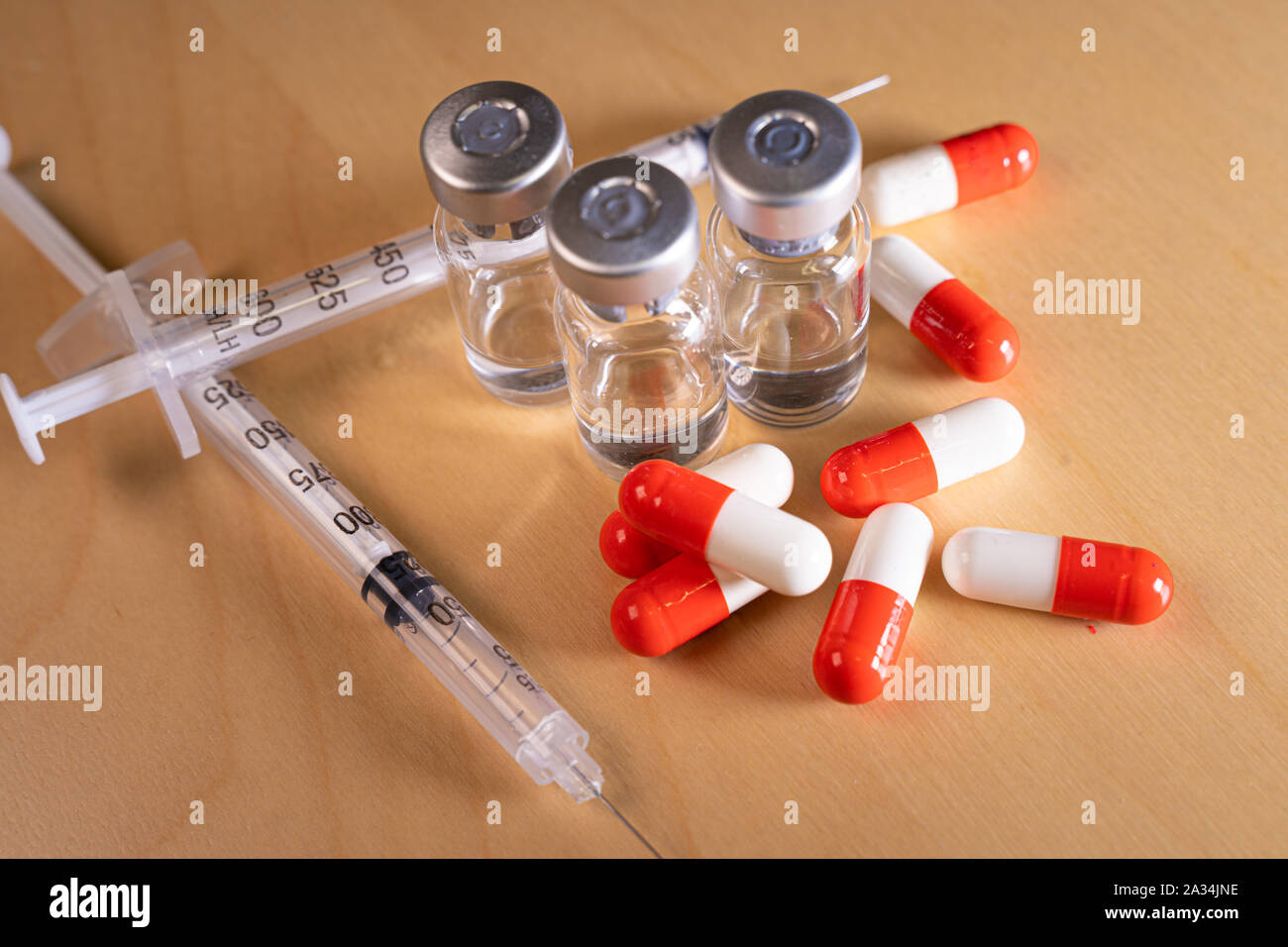 Close up of a hypodermic needle and red pills Stock Photo Alamy