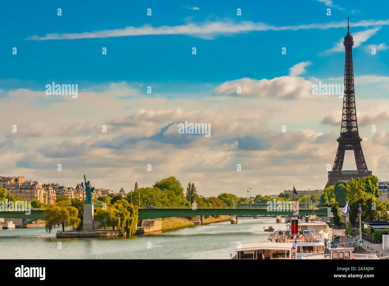 Lovely panoramic view of the Eiffel Tower together with the Statue of Liberty replica on the island Île aux Cygnes and the Pont de Grenelle bridge on Stock Photo