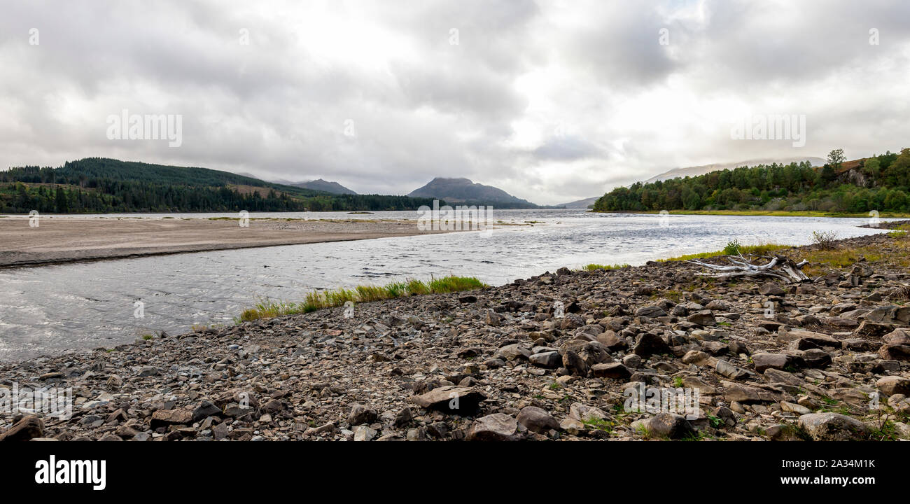 A rocky shore of the River Pattack entering to the Loch Laggan in Scottish Highlands, Cairngorms National park, Scotland Stock Photo