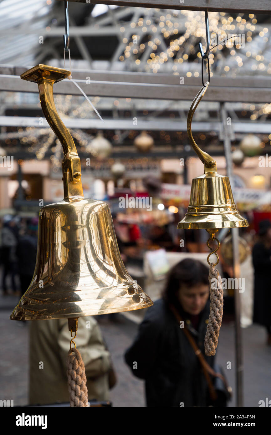 Brass bell, similar to a ships nautical bell, hanging for sale at Greenwich Market, at Christmas. Greenwich, London. UK (105) Stock Photo