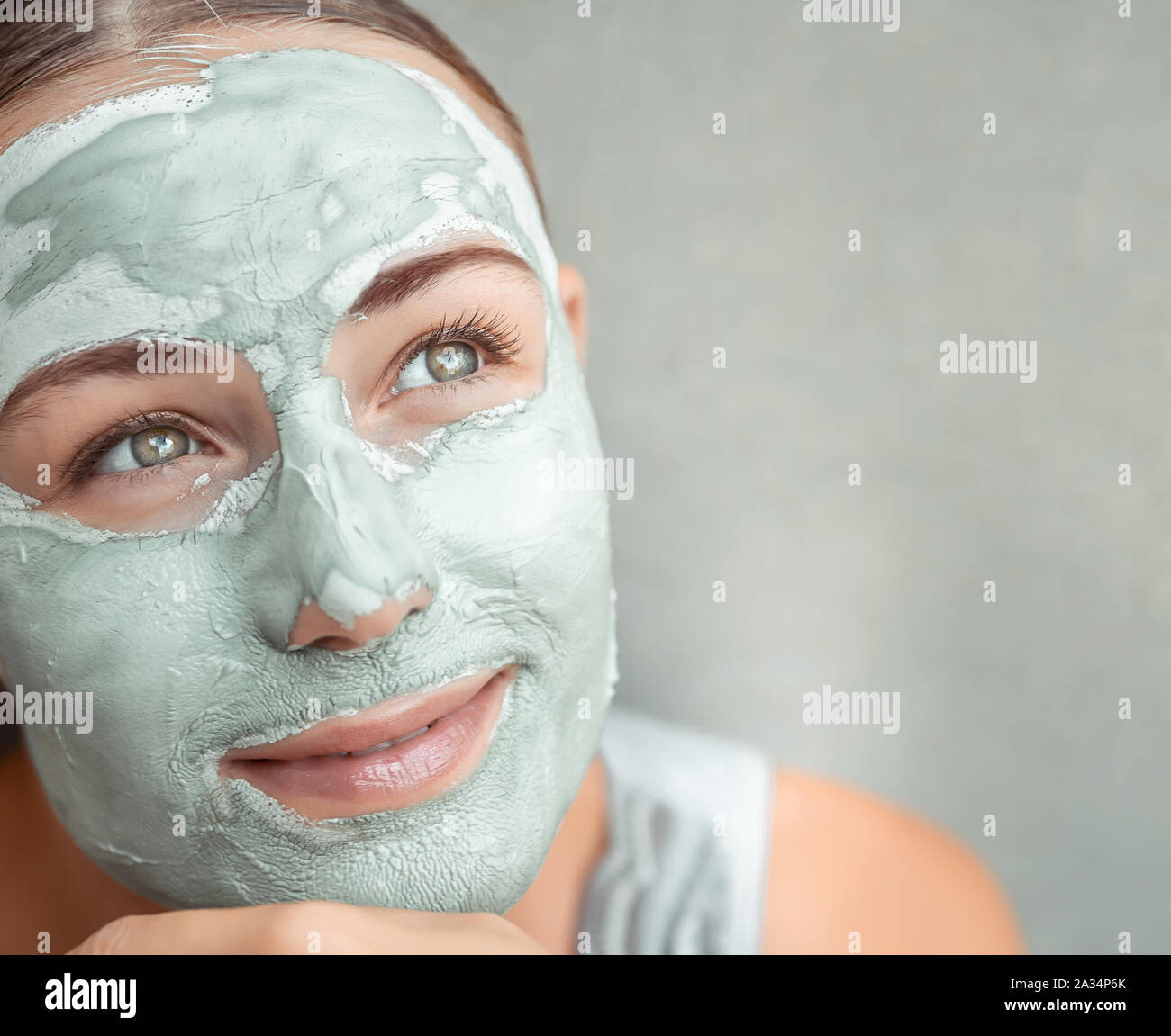 Portrait of a beautiful girl doing facial mask of blue clay, home secrets of facial rejuvenation, photo with copy space, beauty and health care Stock Photo