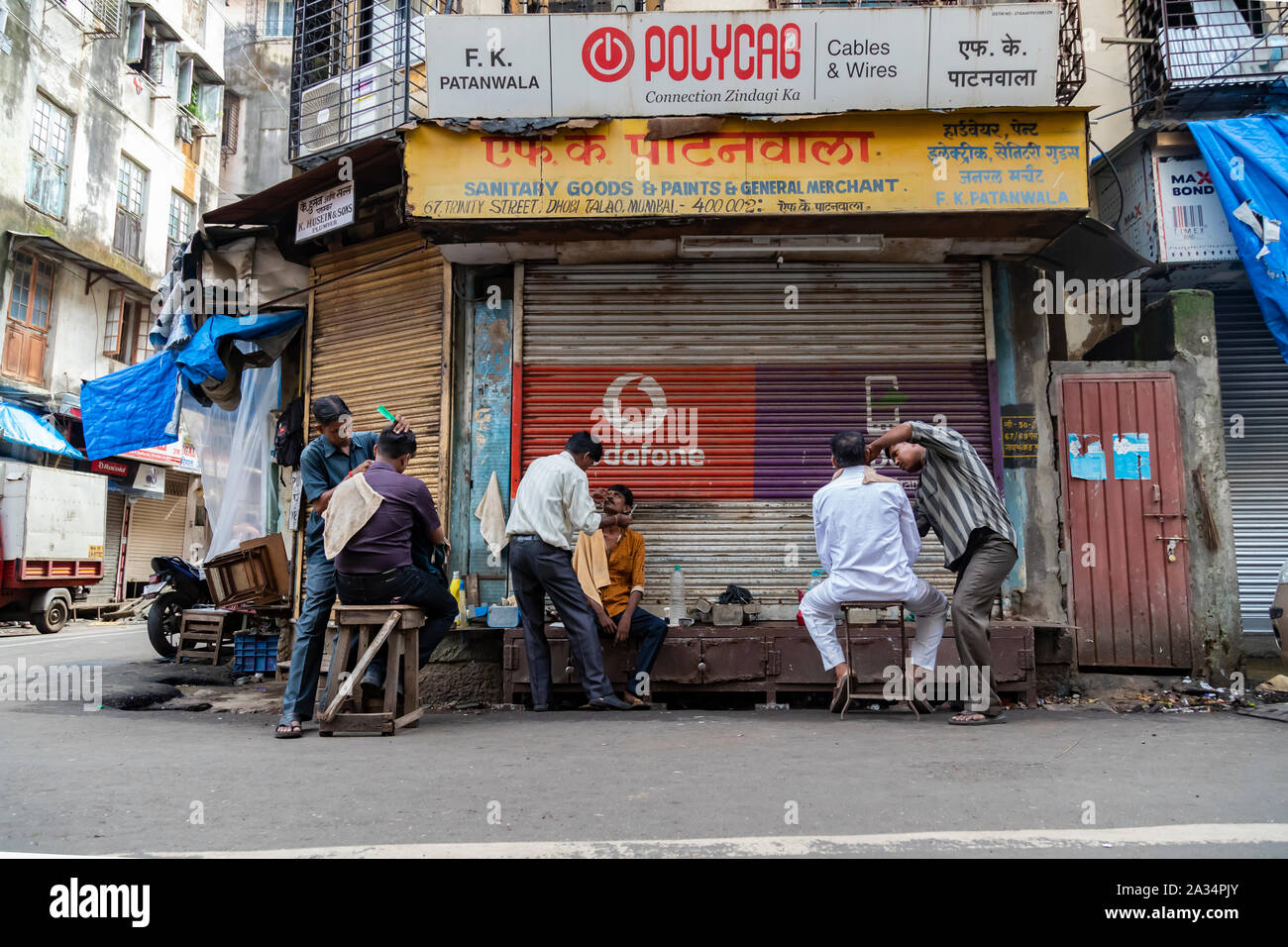 Mumbai ,Maharashtra India August 12 2019 A street barbershop on the backstreet of Fort Market Near Queen Victoria Station. It not only offers quick an Stock Photo