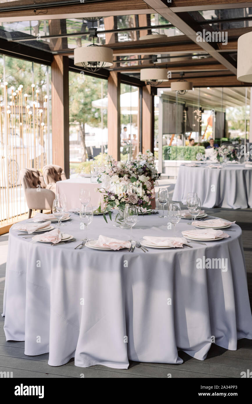 Luxurious wedding design for a modern wedding. Grey tablecloth into the  floor on the roundtable and flowers in the vase Stock Photo - Alamy, image size:867x1390