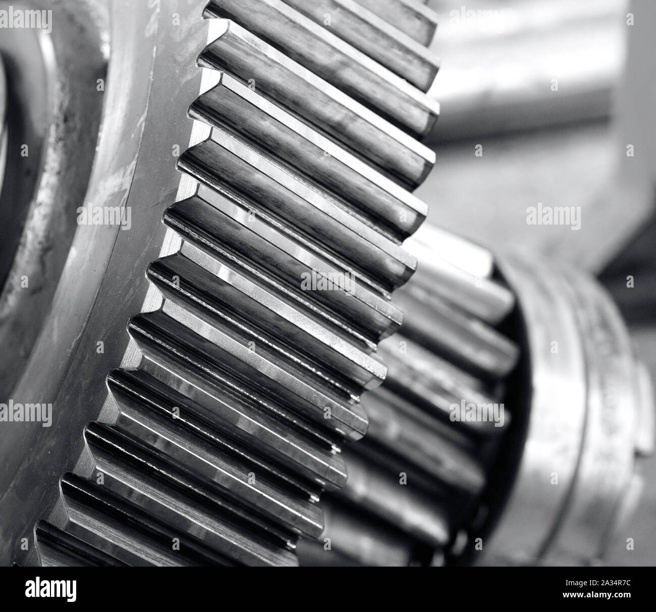 cogwheel of a big gearbox, detail of the teeths mechanized, industrial photo in black and white Stock Photo