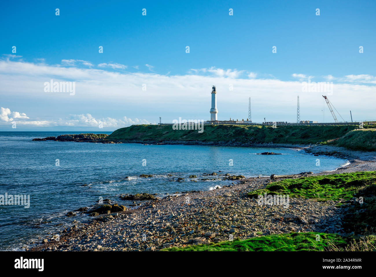 A view to lighthouse Girdle Ness from a rocky pebble beach near it, Aberdeen, Scotland Stock Photo
