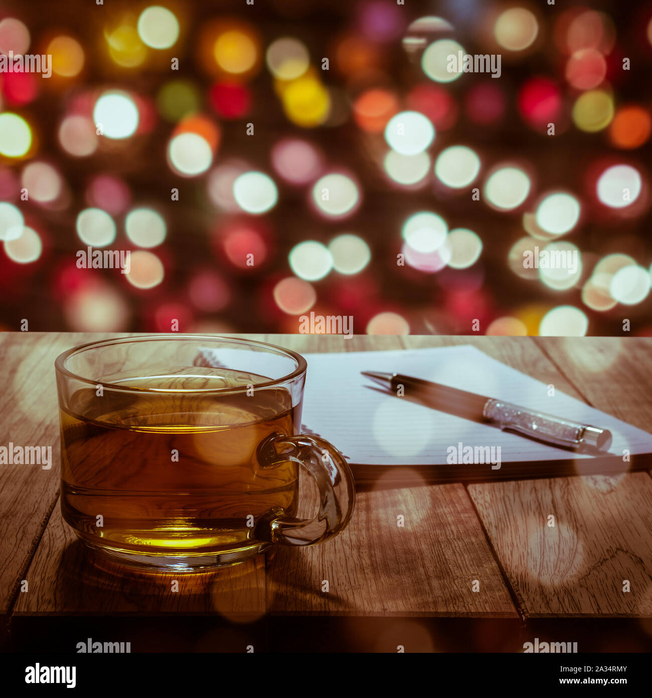 Hot tea with notebook and pen on wooden table in colorful bokeh background  Stock Photo - Alamy
