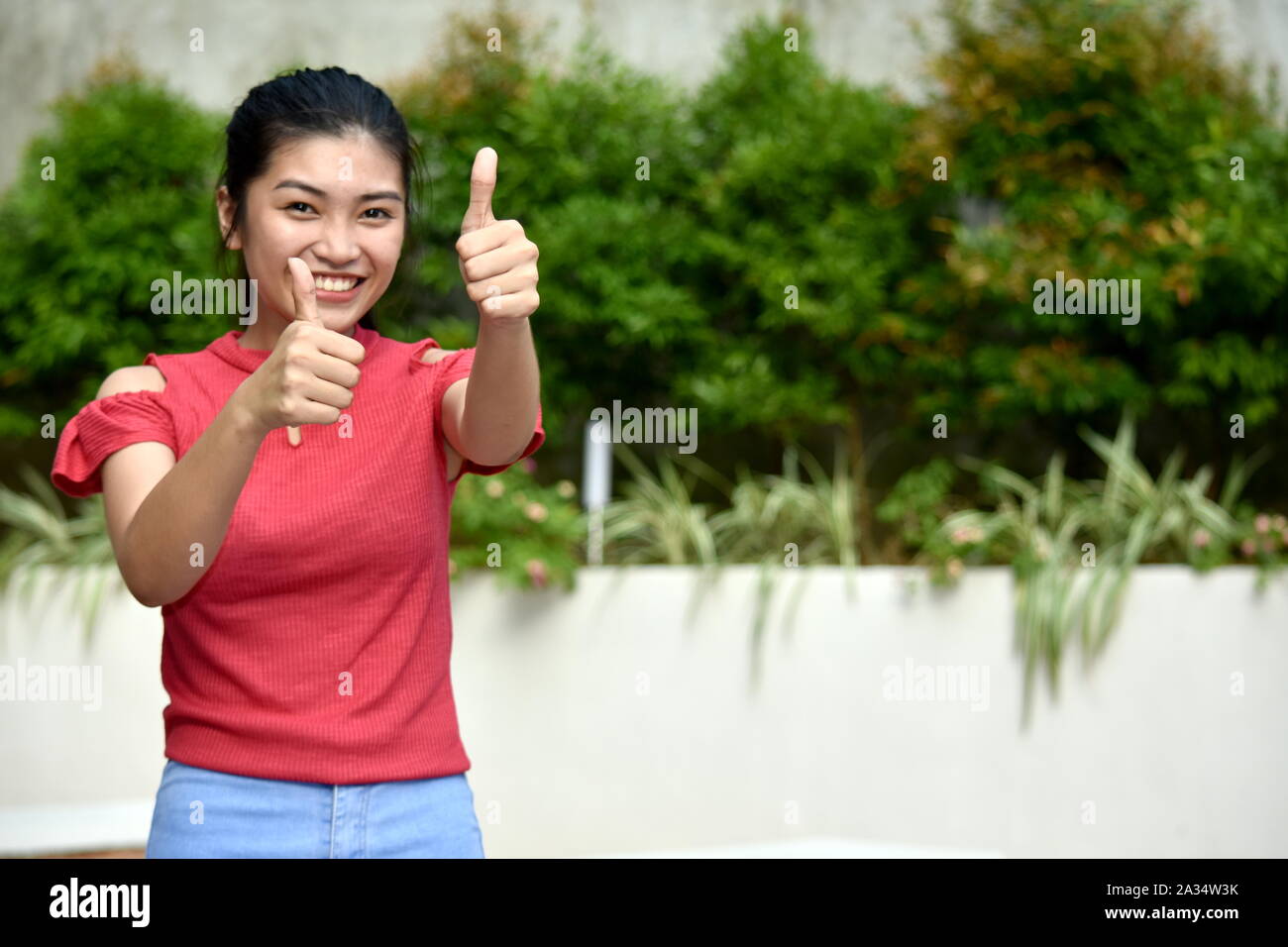 Youthful Asian Girl With Thumbs Up Stock Photo - Alamy