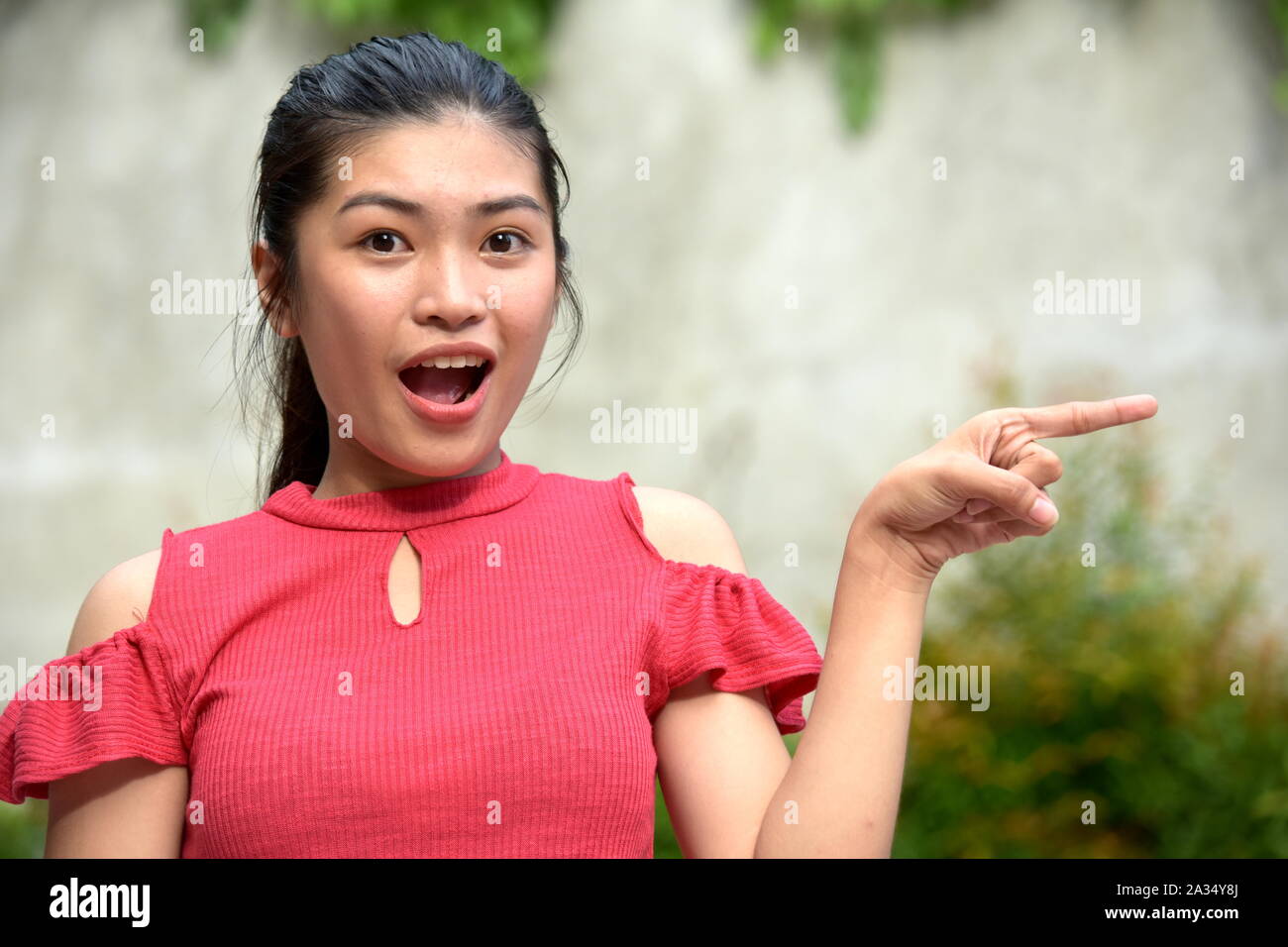 A Pointing Pretty Asian Girl Teenager Stock Photo - Alamy