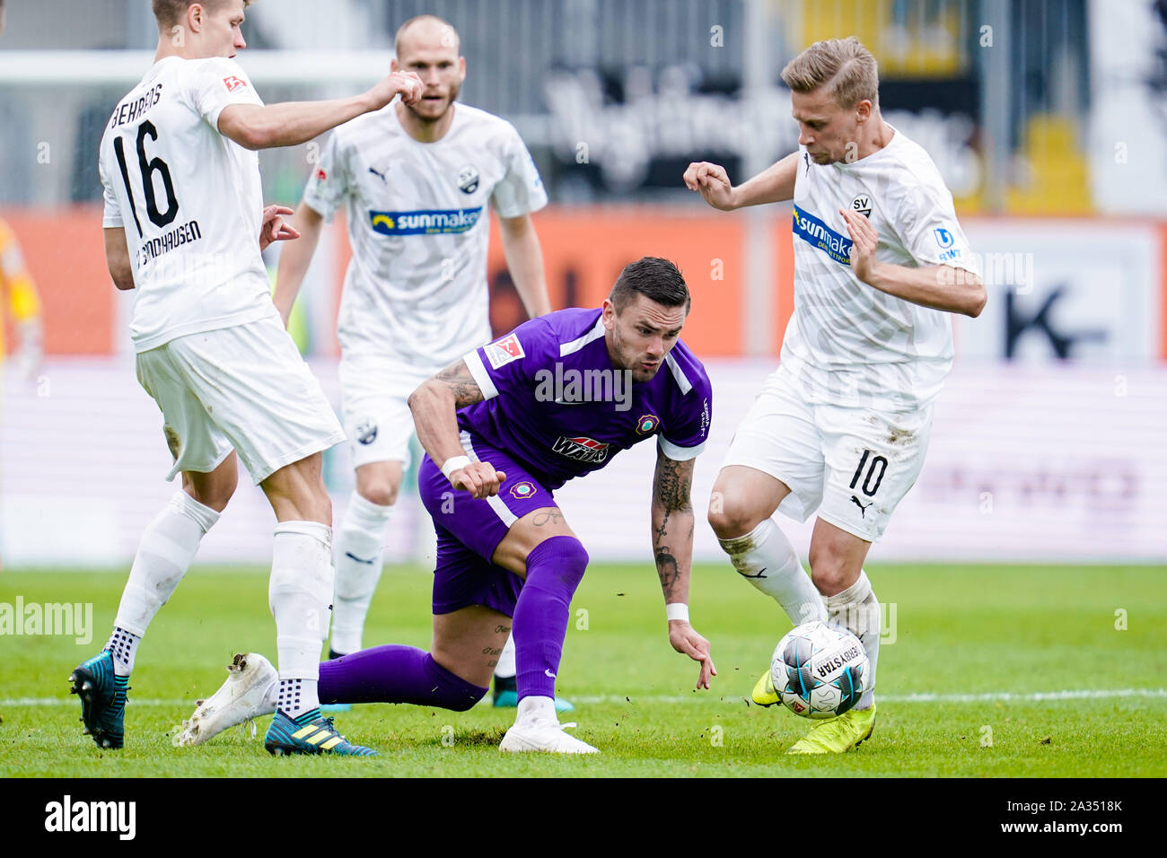 05 October 2019, Baden-Wuerttemberg, Sandhausen: Soccer: 2nd Bundesliga, SV Sandhausen - Erzgebirge Aue, 9th matchday, in Hardtwaldstadion. Sandhausens Kevin Behrens (l-r), Pascal Testroet from Erzgebirge Aue and Sandhausens Julius Biada fight for the ball. In the background is Gerrit Nauber con Sandhausen. Photo: Uwe Anspach/dpa - IMPORTANT NOTE: In accordance with the requirements of the DFL Deutsche Fußball Liga or the DFB Deutscher Fußball-Bund, it is prohibited to use or have used photographs taken in the stadium and/or the match in the form of sequence images and/or video-like photo sequ Stock Photo