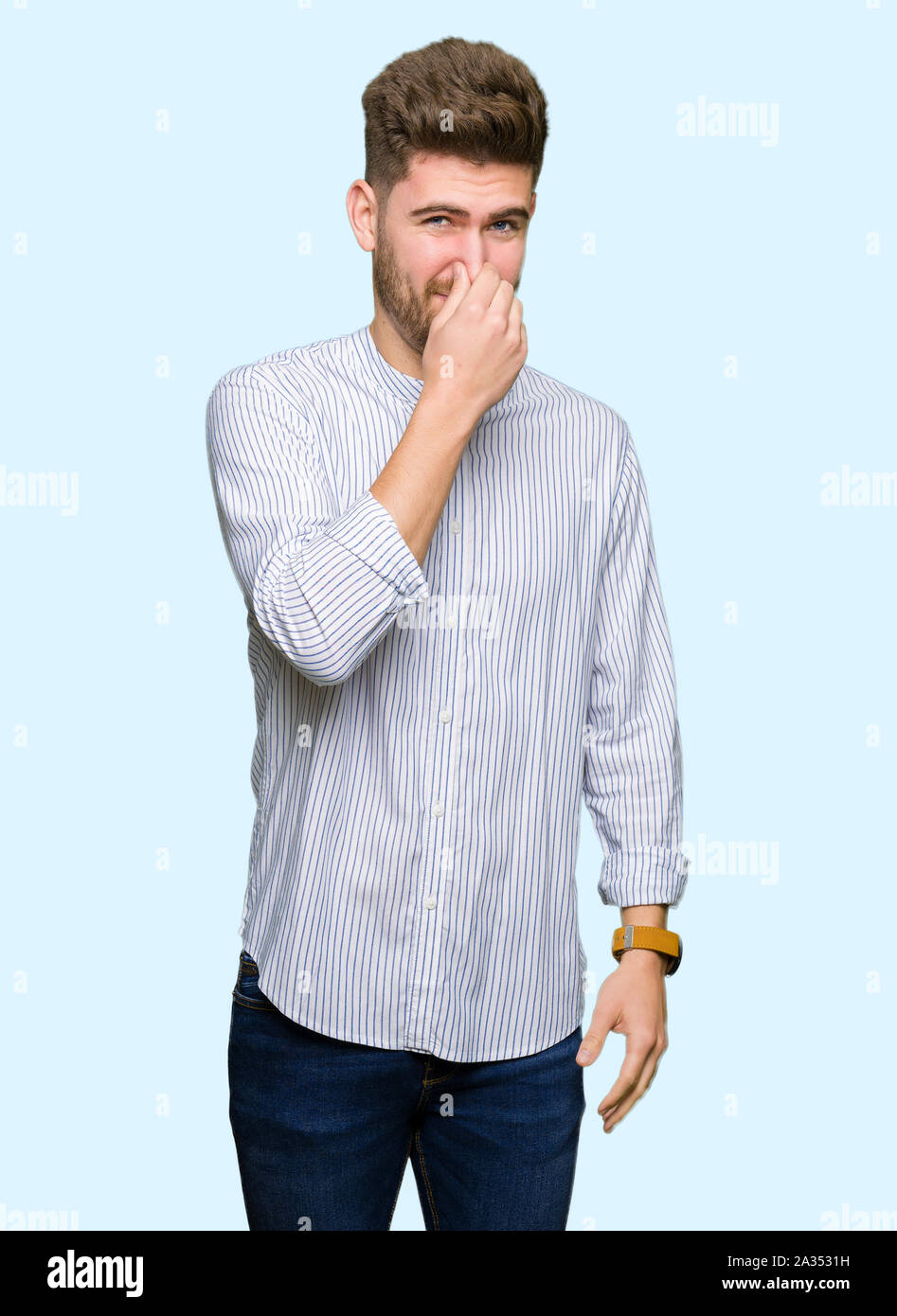 Young handsome man smelling something stinky and disgusting, intolerable  smell, holding breath with fingers on nose. Bad smells concept Stock Photo  - Alamy, image size:947x1390