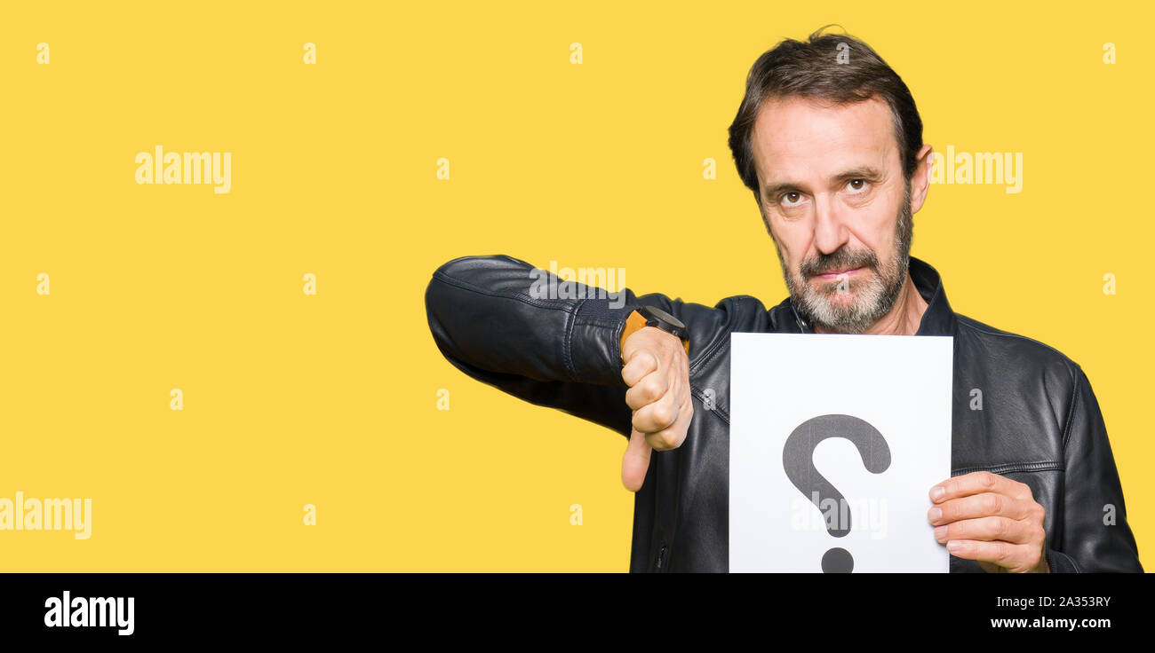 Handsome middle age man holding paper with question mark with angry ...