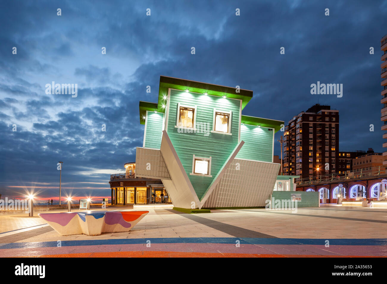 Night falls at the 'Upside Down House' on Brighton seafront, East Sussex. Stock Photo