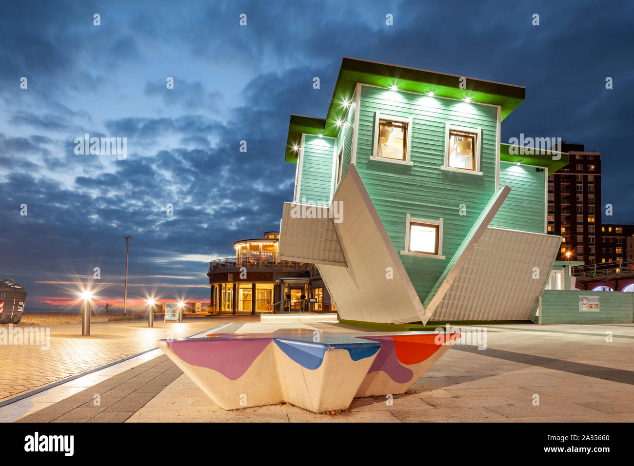 Night falls at the 'Upside Down House' on Brighton seafront, East Sussex. Stock Photo