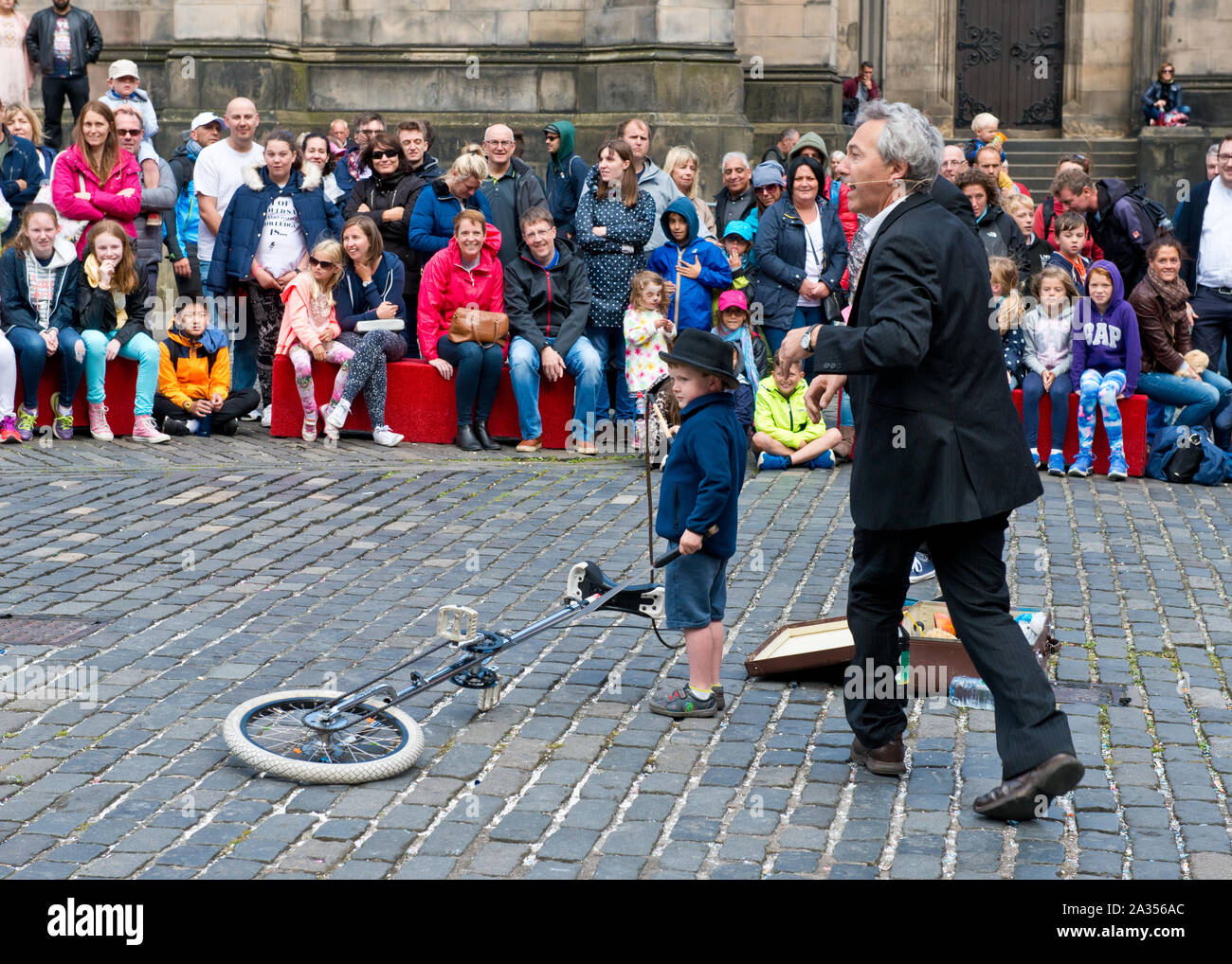 Young boy from audience enjoying taking part in street act. Edinburgh Fringe Festival Stock Photo