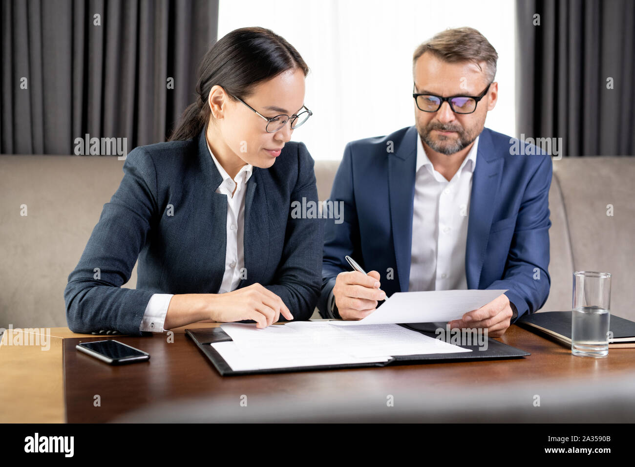 Confident businessman showing his business partner where to sign ...