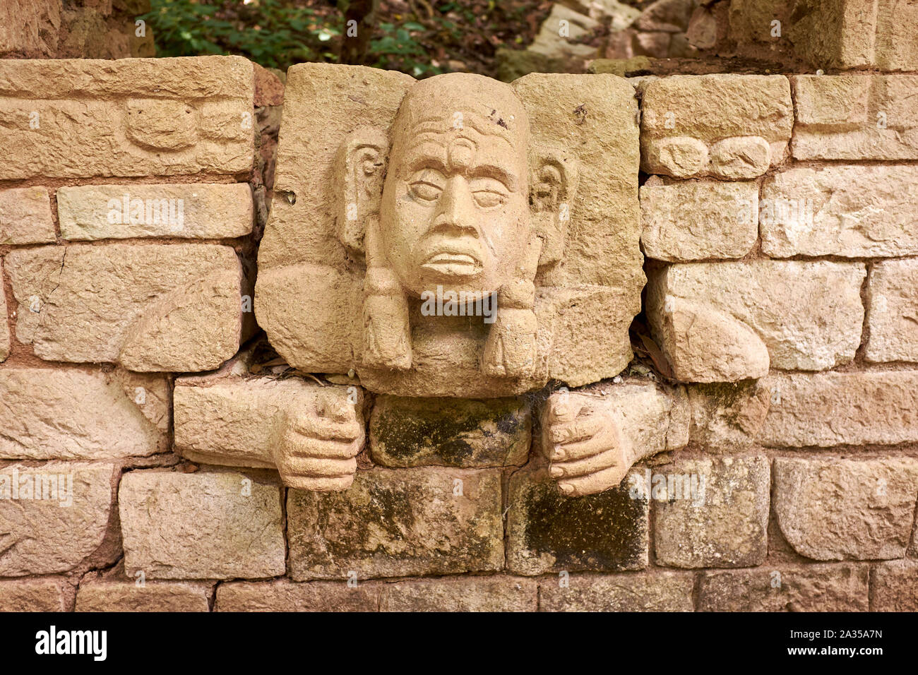 Faces carved by the Mayan's protrude from a wall at Copan Ruins, Copan, Honduras Stock Photo