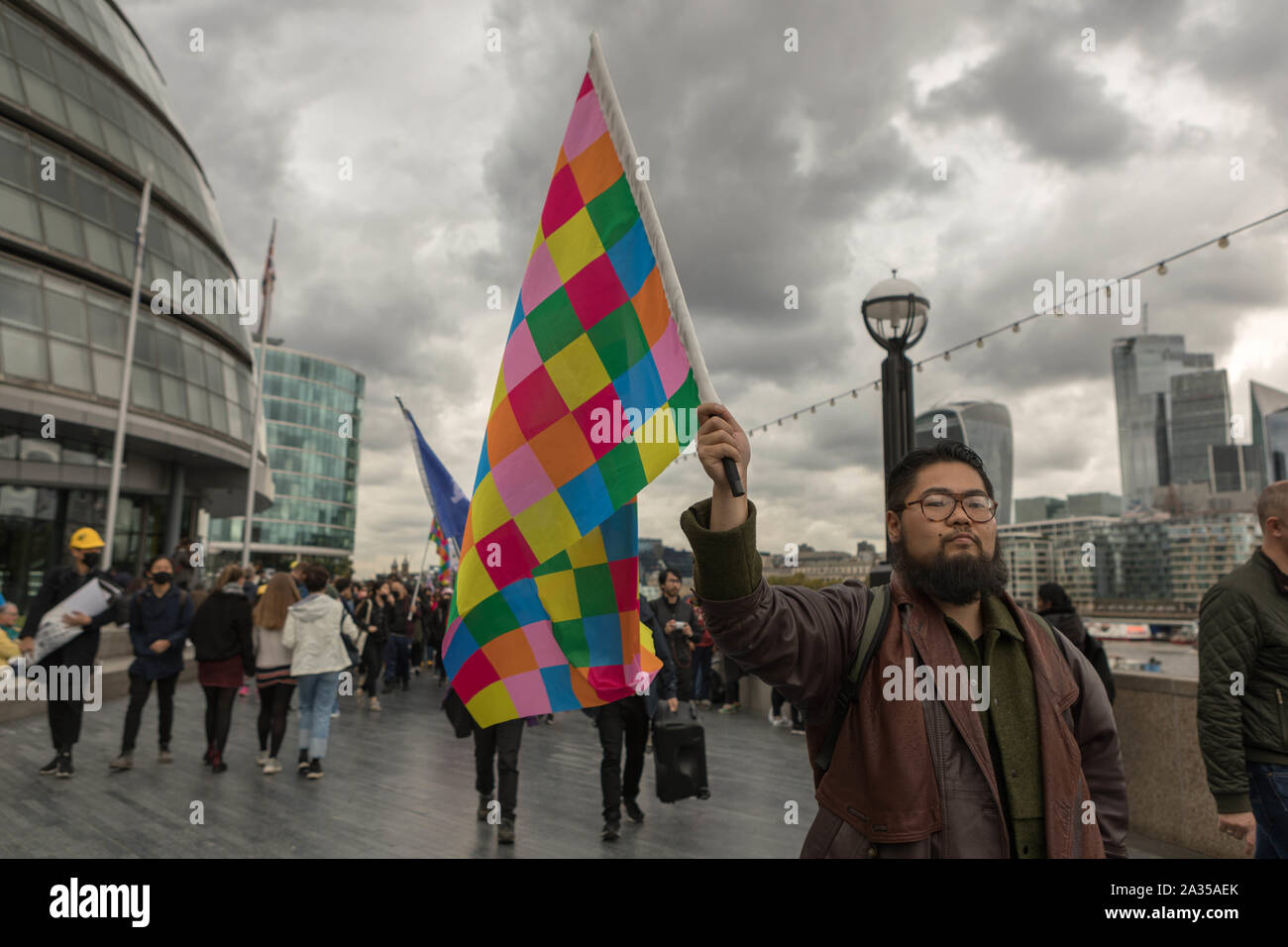 London, UK. 5th Oct, 2019. Chinese artist Badiucao and supporters join hands in a human chain, a showing of solidarity with protesters in Hong Kong. The Lennon Wall flag, symbolising Hong Kongs fight for freedom is also symbolically raised. Penelope Barritt/Alamy Live News Stock Photo