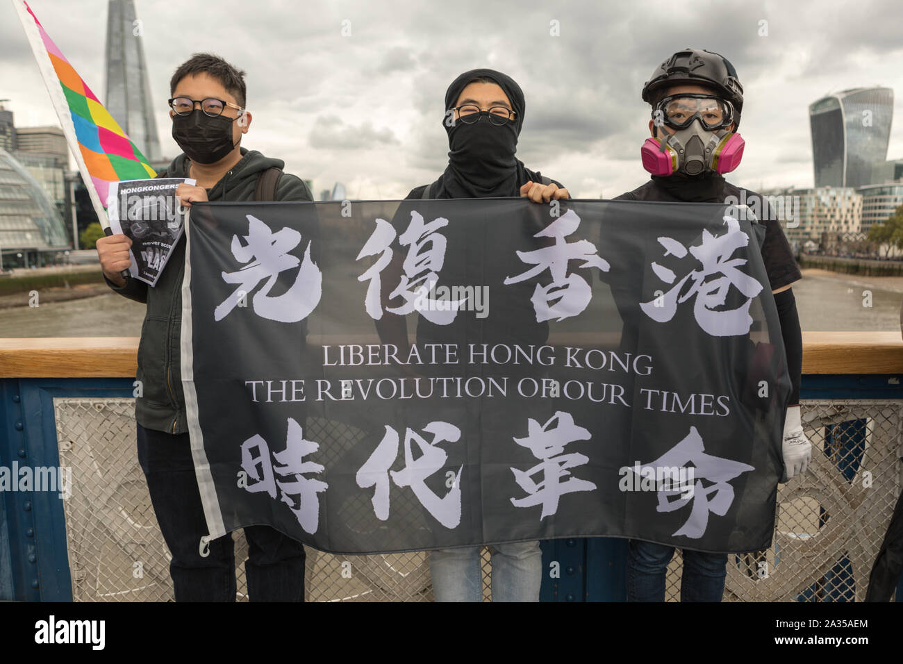 London, UK. 5th Oct, 2019. Chinese artist Badiucao and supporters join hands in a human chain, a showing of solidarity with protesters in Hong Kong. The Lennon Wall flag, symbolising Hong Kongs fight for freedom is also symbolically raised. Penelope Barritt/Alamy Live News Stock Photo